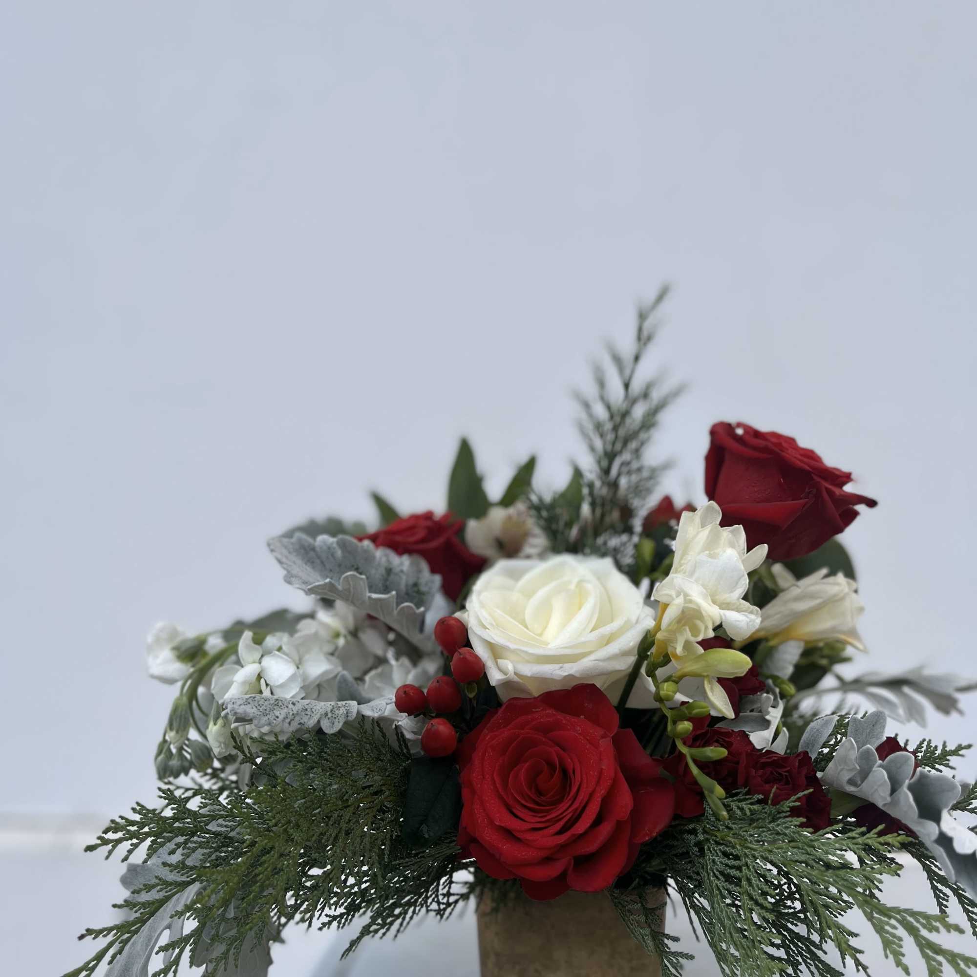 The Winter Charm is a petite yet striking arrangement that captures the