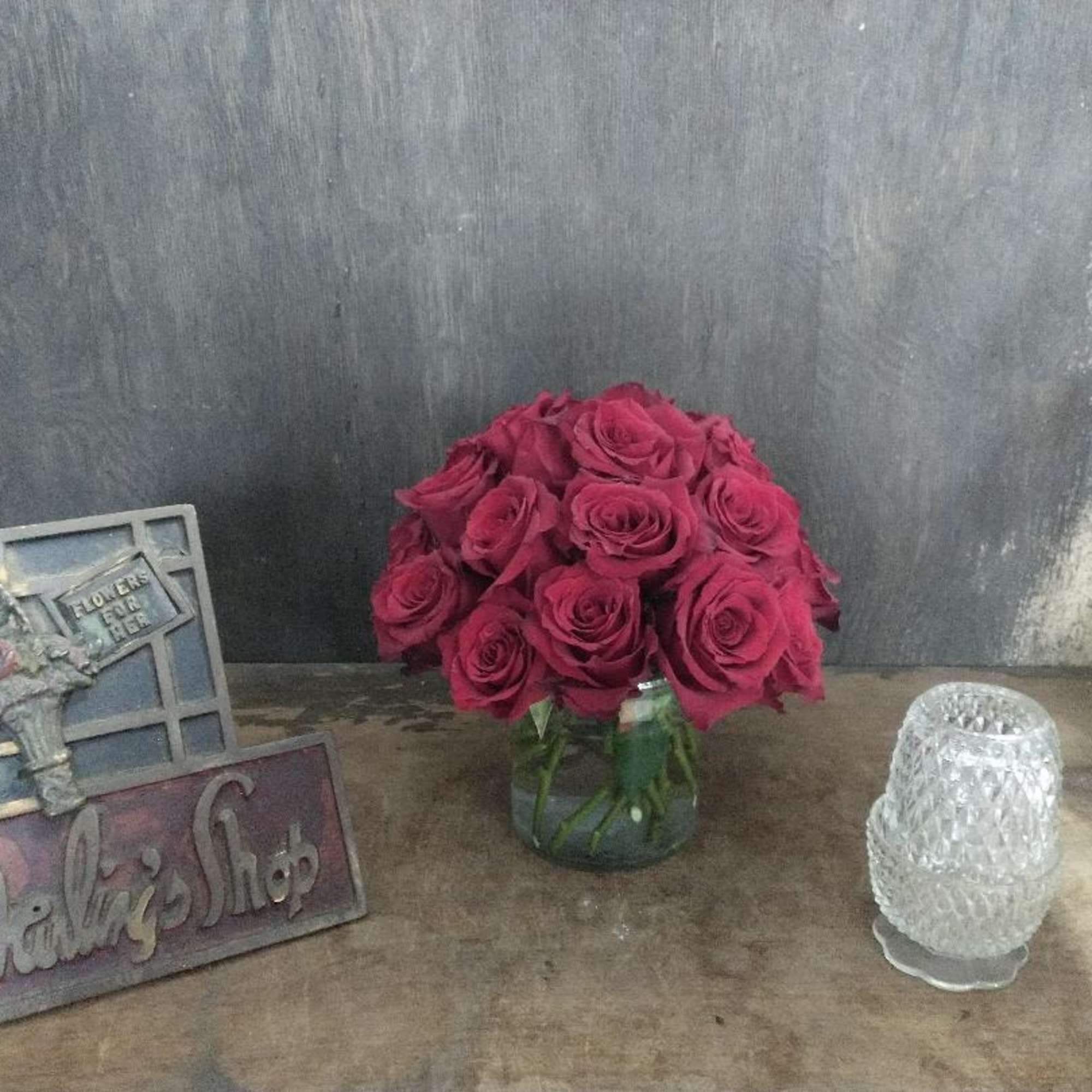 2 Dozen red roses in a low container.   Comes in