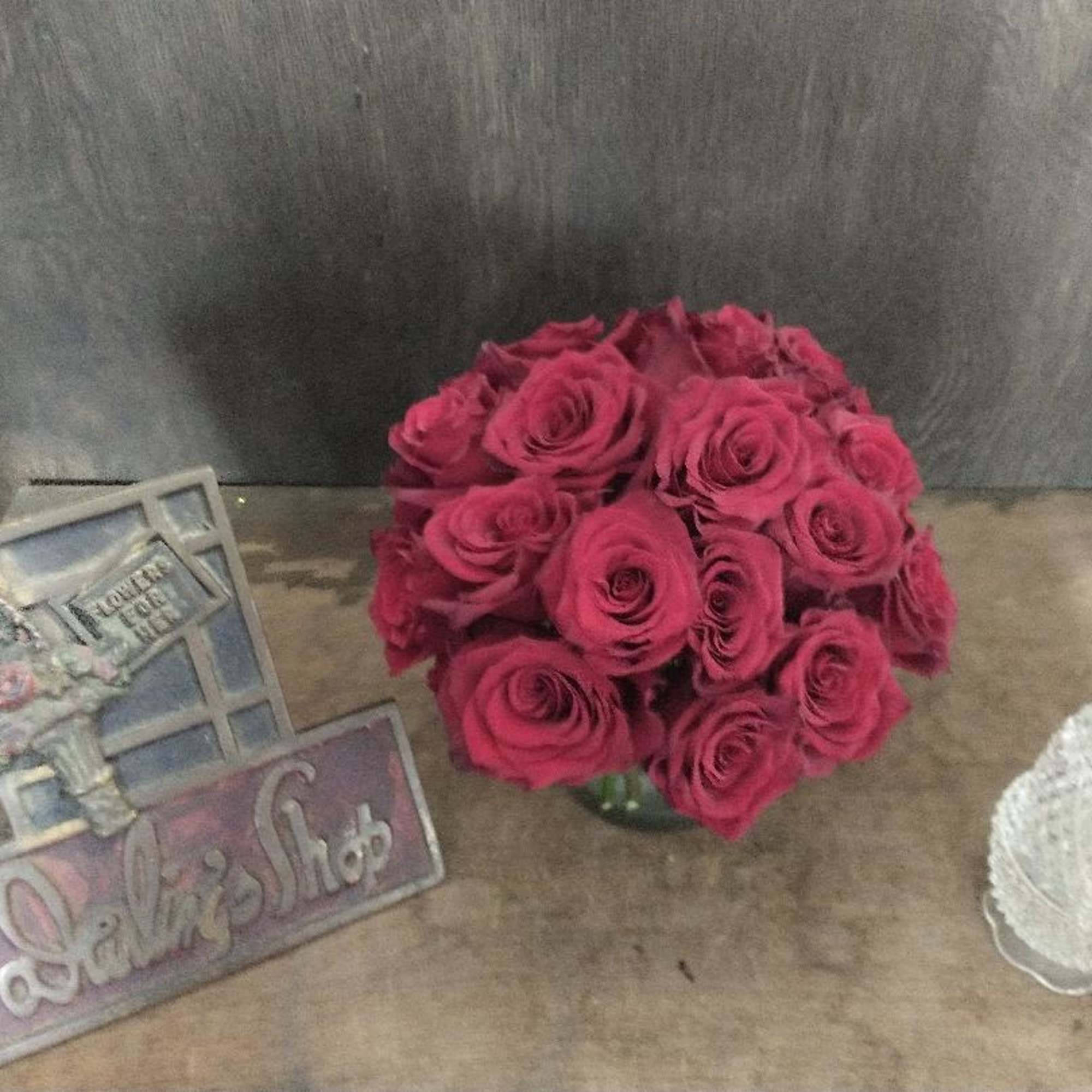 2 Dozen red roses in a low container.   Comes in