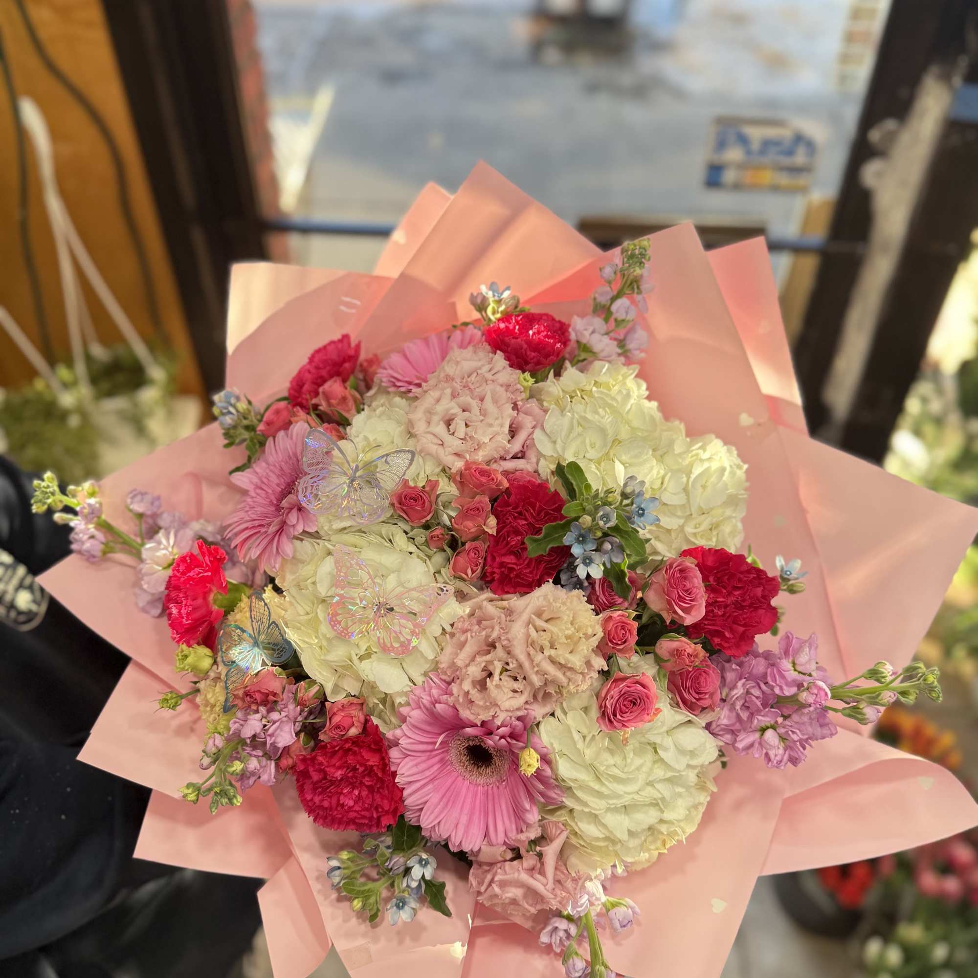 This lush hand-tied arrangement features a romantic blend of blush and hot