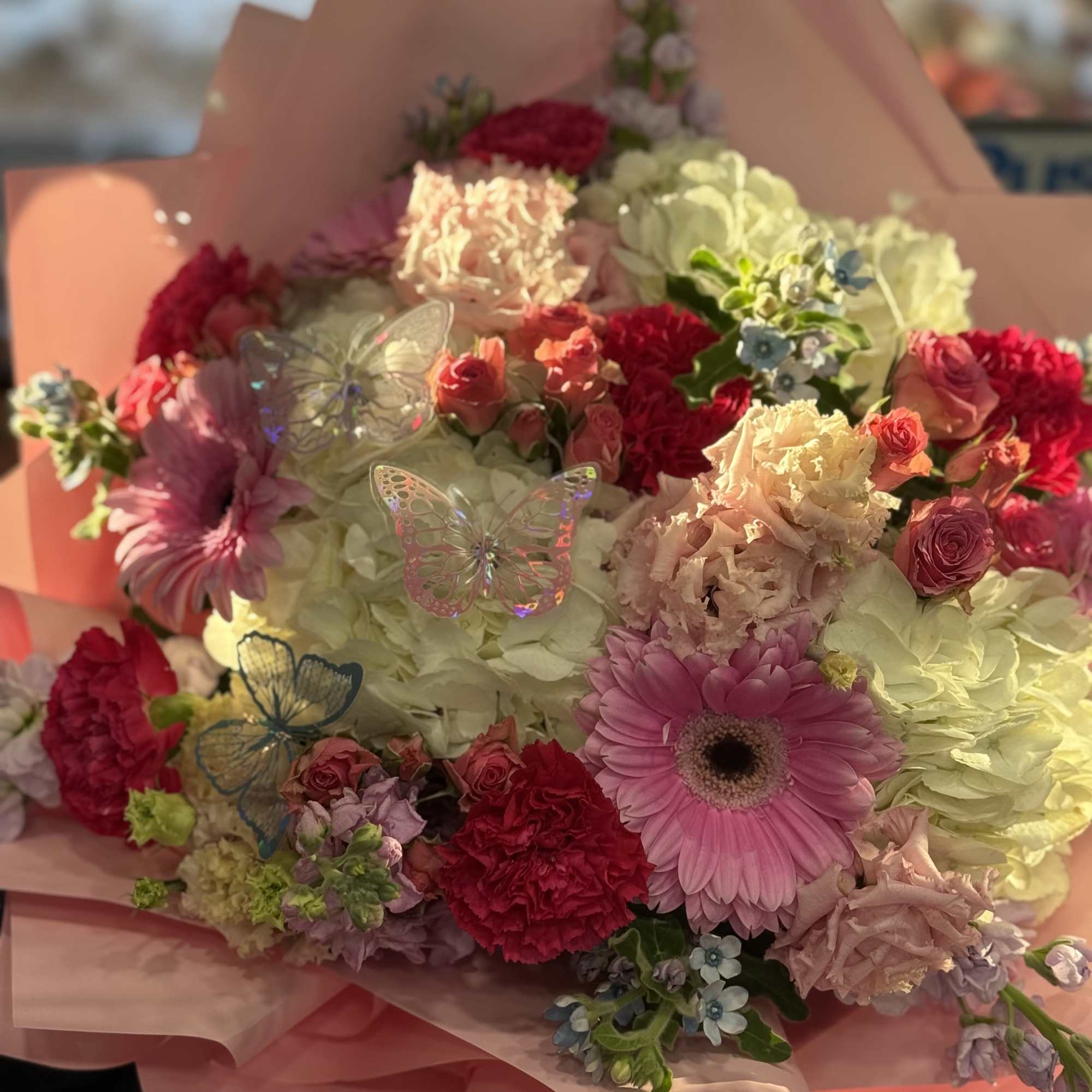 This lush hand-tied arrangement features a romantic blend of blush and hot