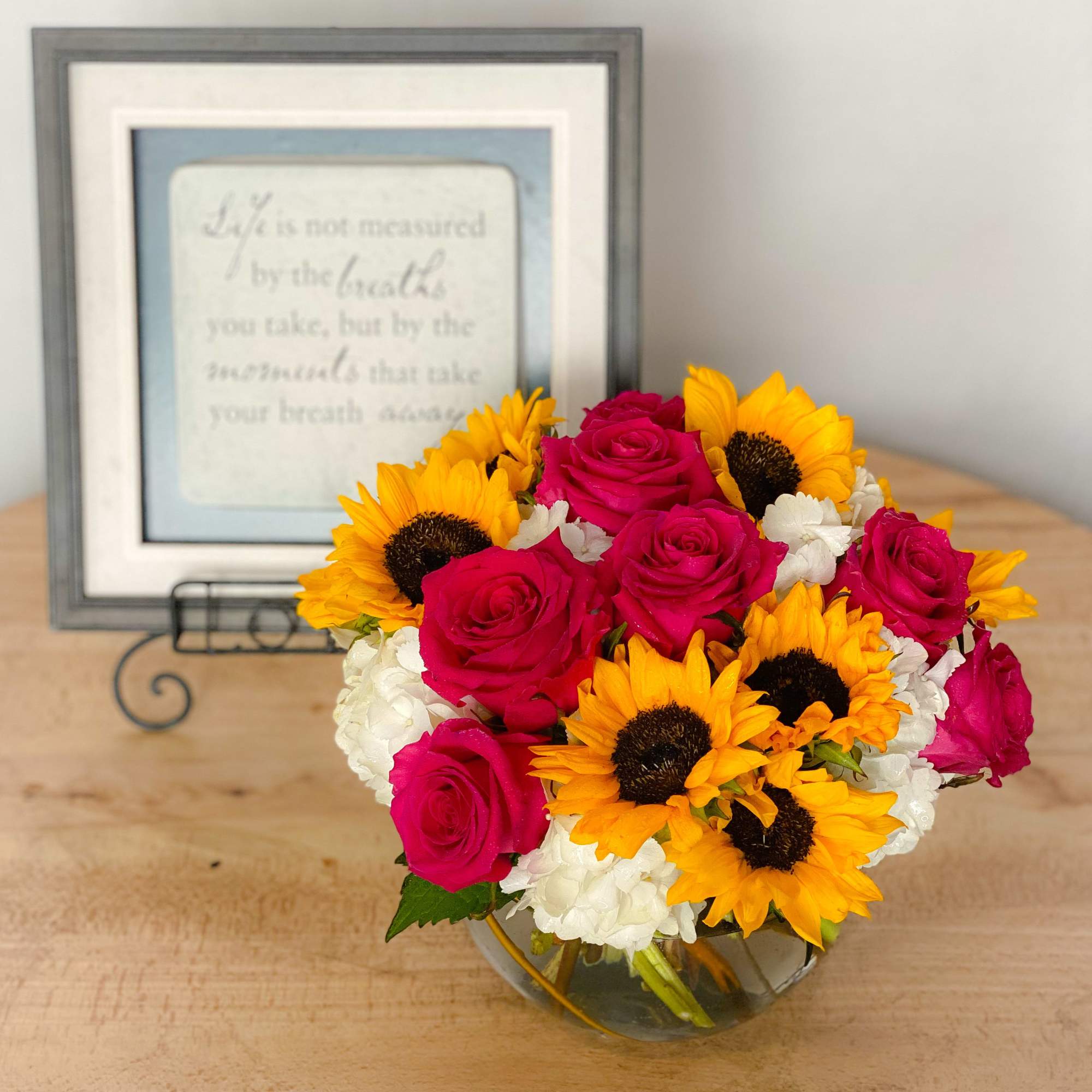 Precious pink roses and exotic sunflowers designed on a bed of luscious