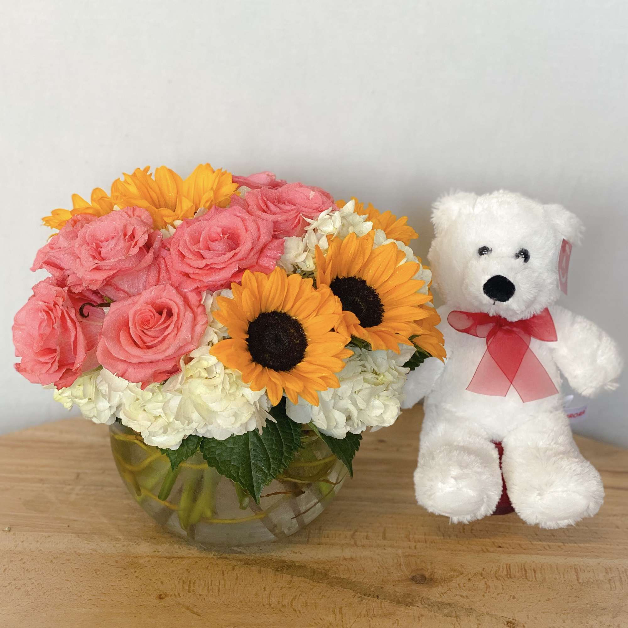 Precious pink roses and exotic sunflowers designed on a bed of luscious