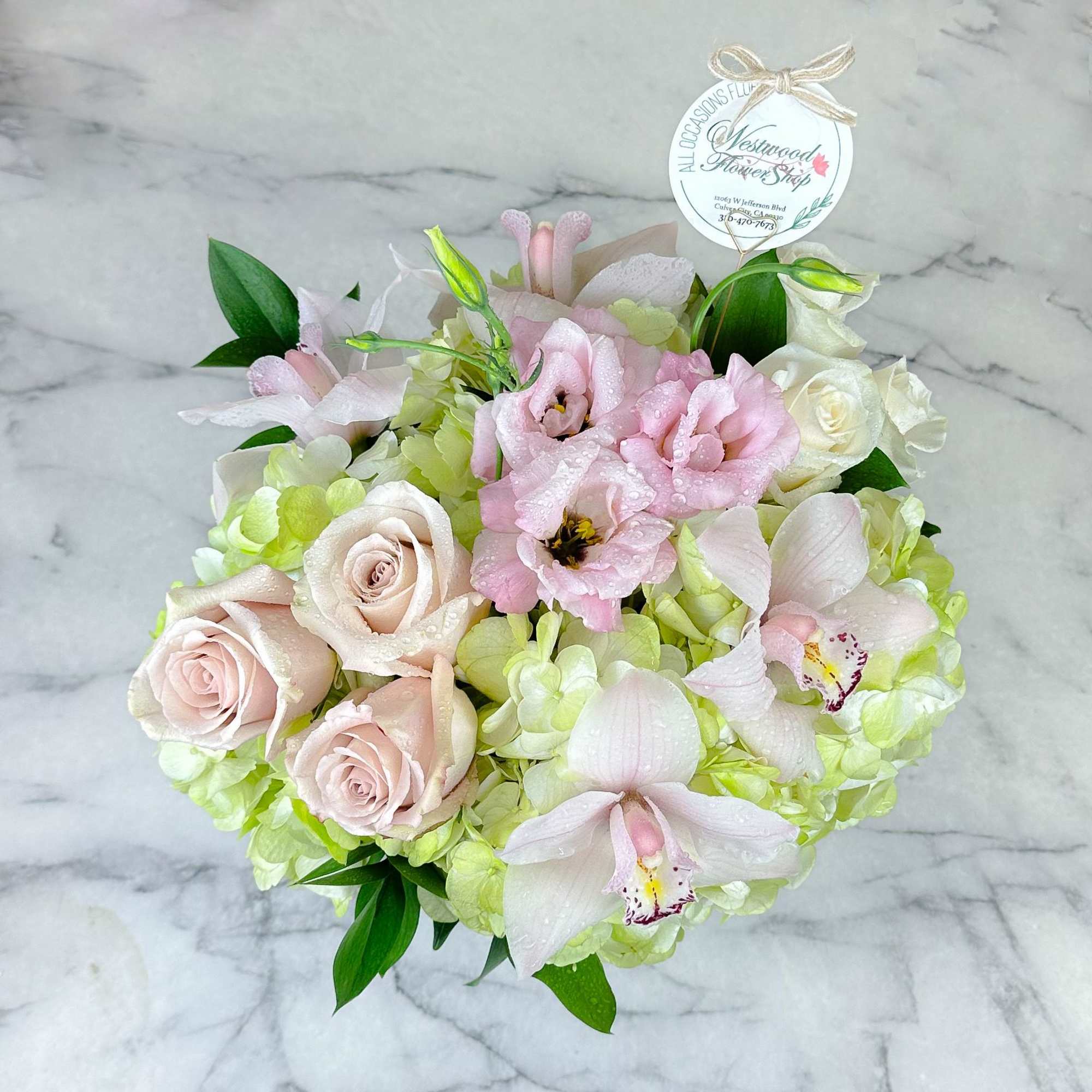 This elegant bouquet of cymbidium orchids, roses and hydrangeas arranged in a