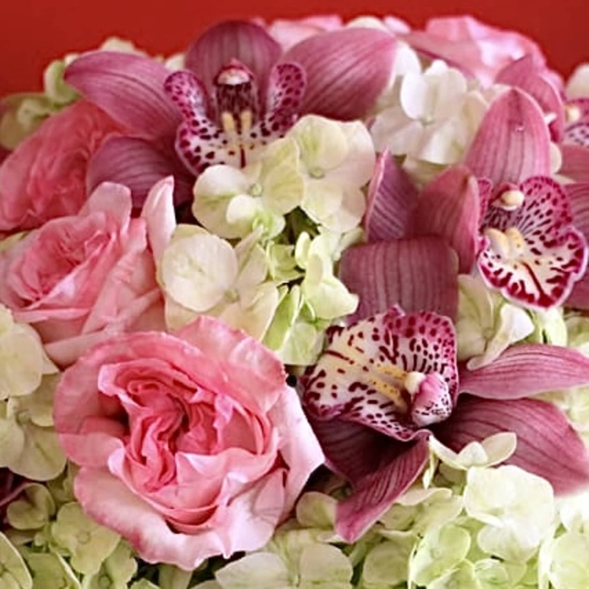 A dazzling bouquet of lush pink cymbidium orchids and roses designed on