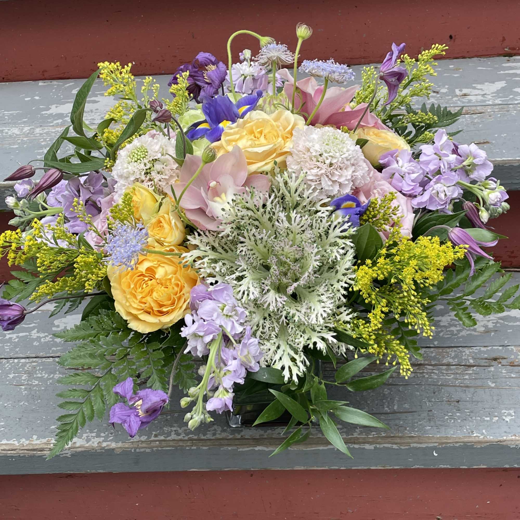 Deluxe size pictured

A beautiful arrangement of seasonal flowers in shades of purple