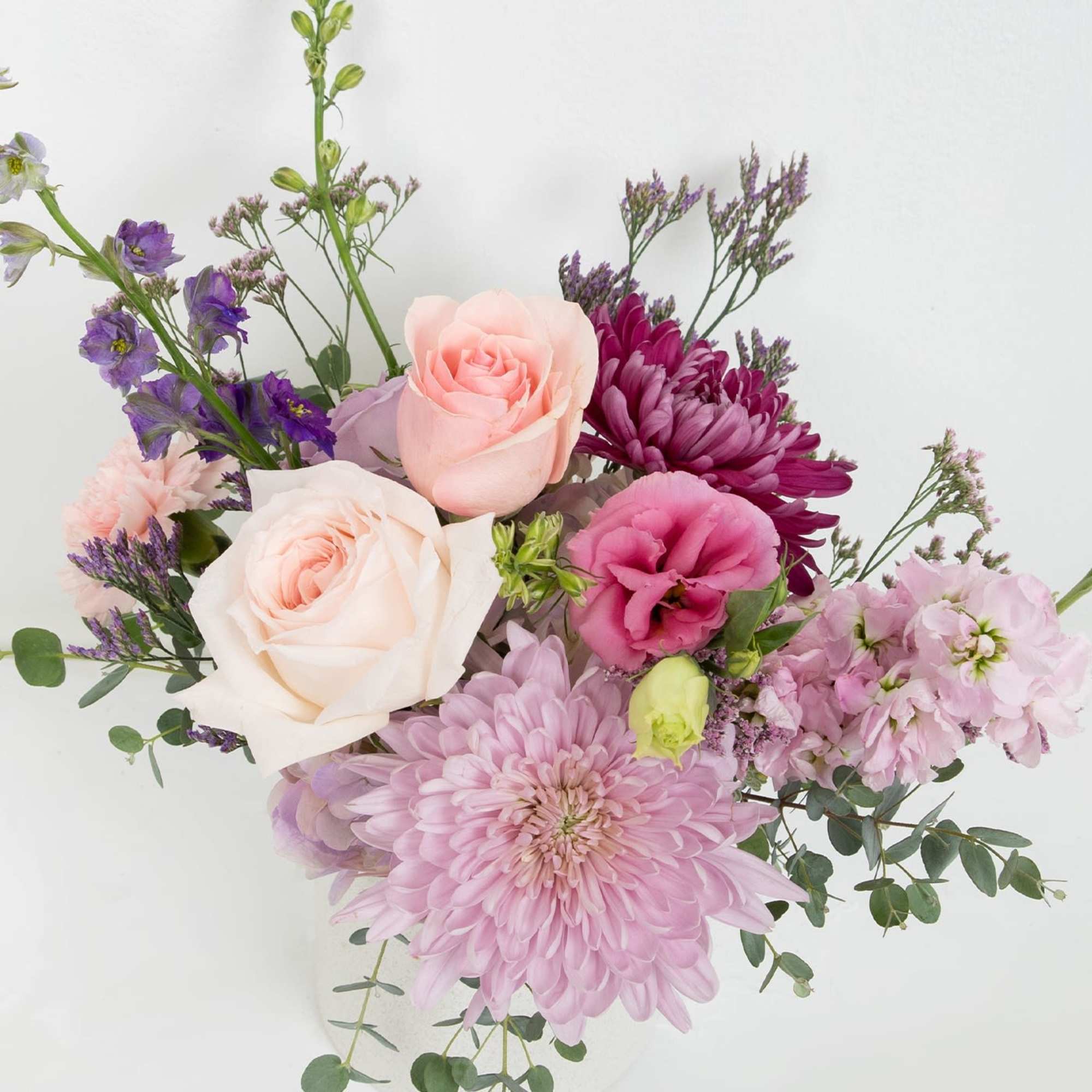 Soft, elegant vase arrangement featuring pastel pink, lavender and purple blooms with