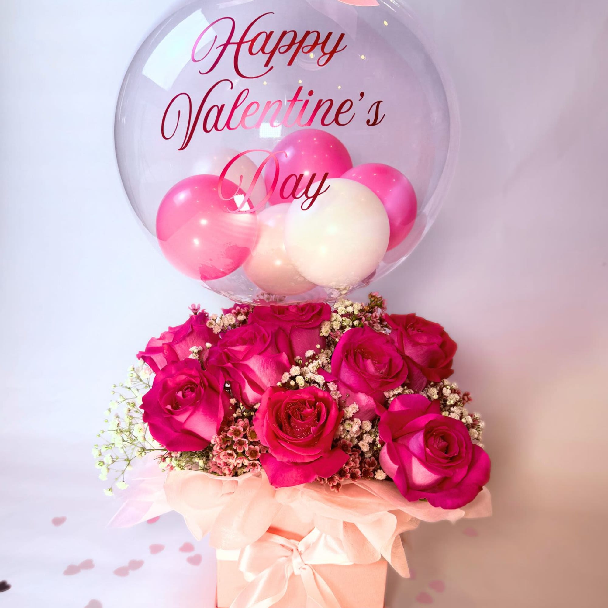 At the center is a lush bouquet of one dozen pink roses