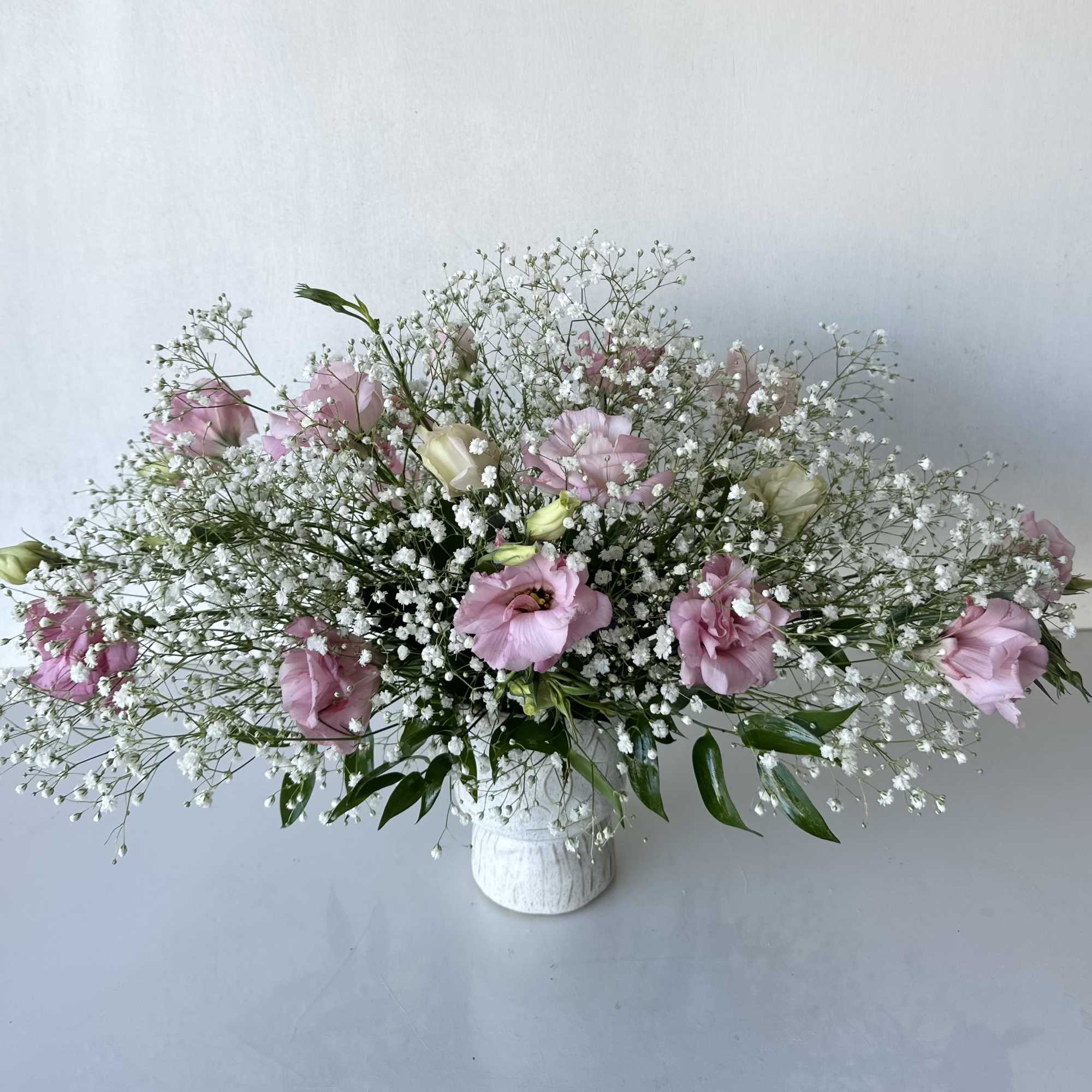 A simple, modern arrangement of pink lisianthus and baby's breath. This floral