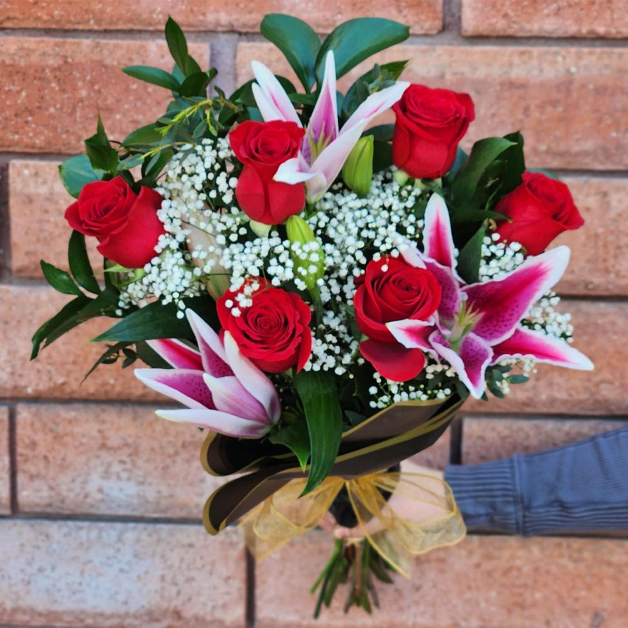Luxurious long-stem red Ecuadorian Mountain roses and fragrant pink stargazer lilies nestled