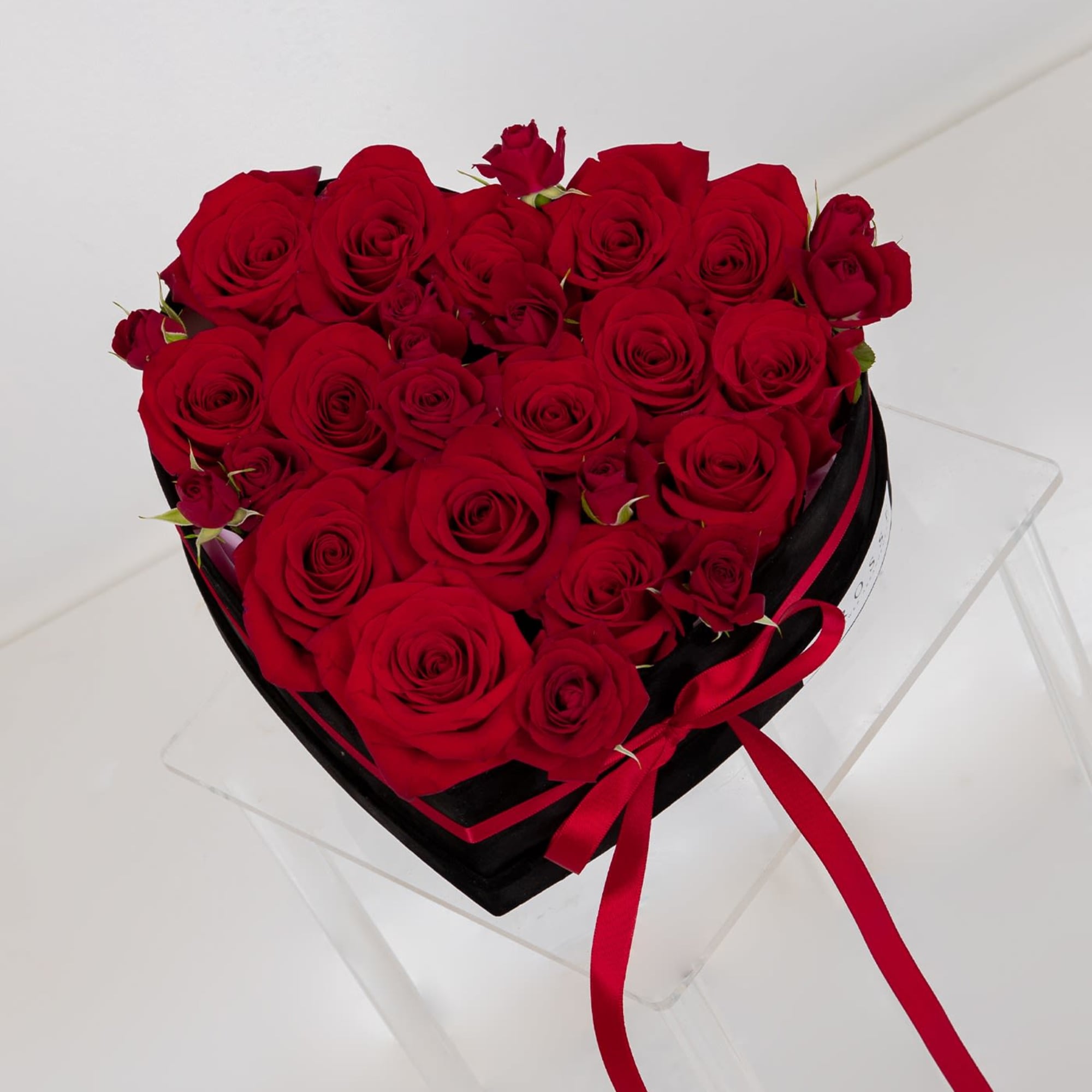 A heart-shaped black Velvet box with Roses and Spray roses.
Flowers colors can
