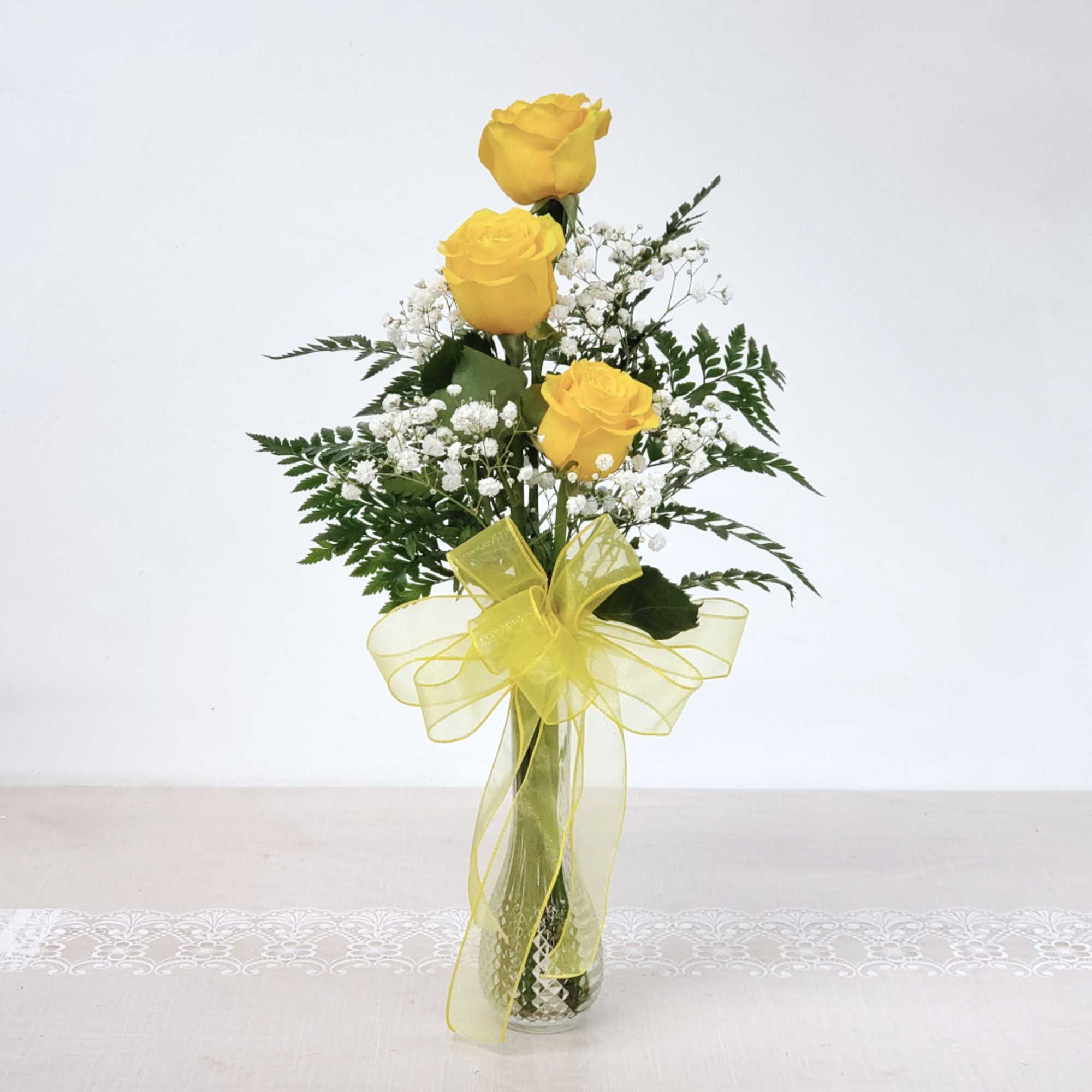 Three yellow roses in a stylish bud vase. Makes a great gift