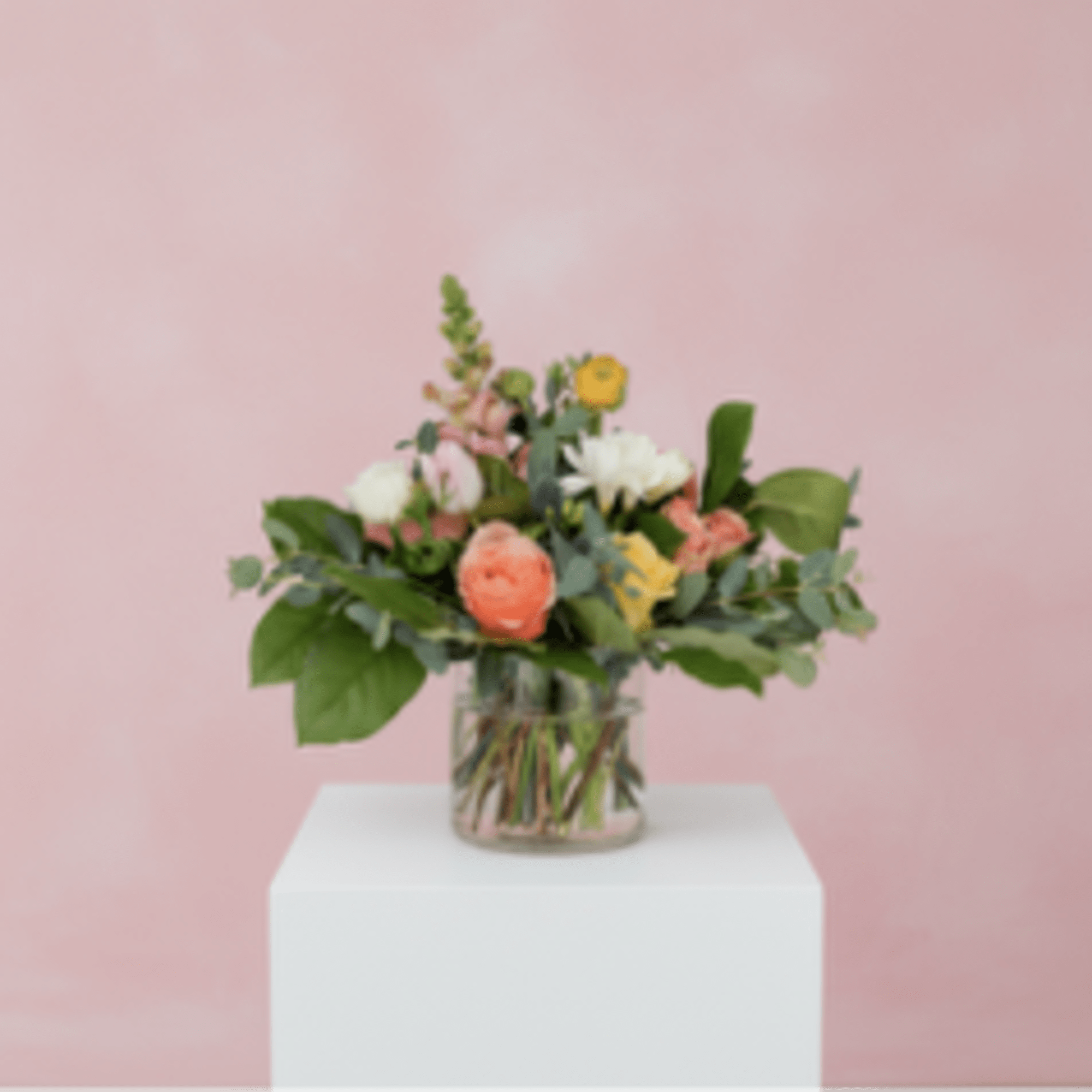 Seasonal blooms &amp; foliage in a clear petite vase.