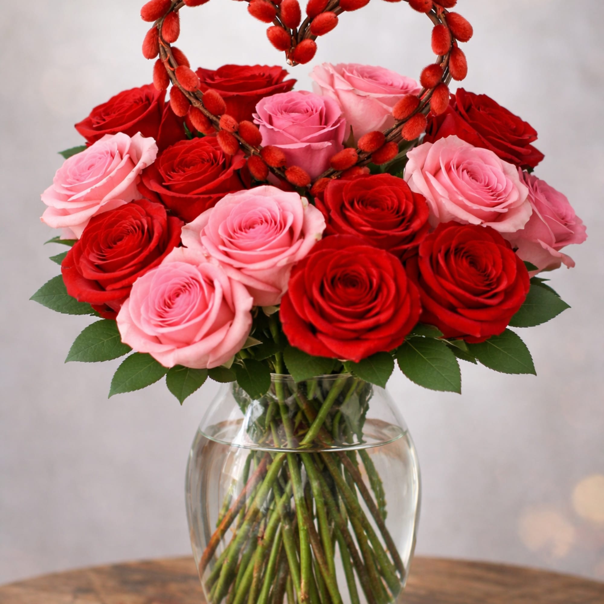 Red and pink roses, babysbreath adorned with a salix heart. Bouquet is
