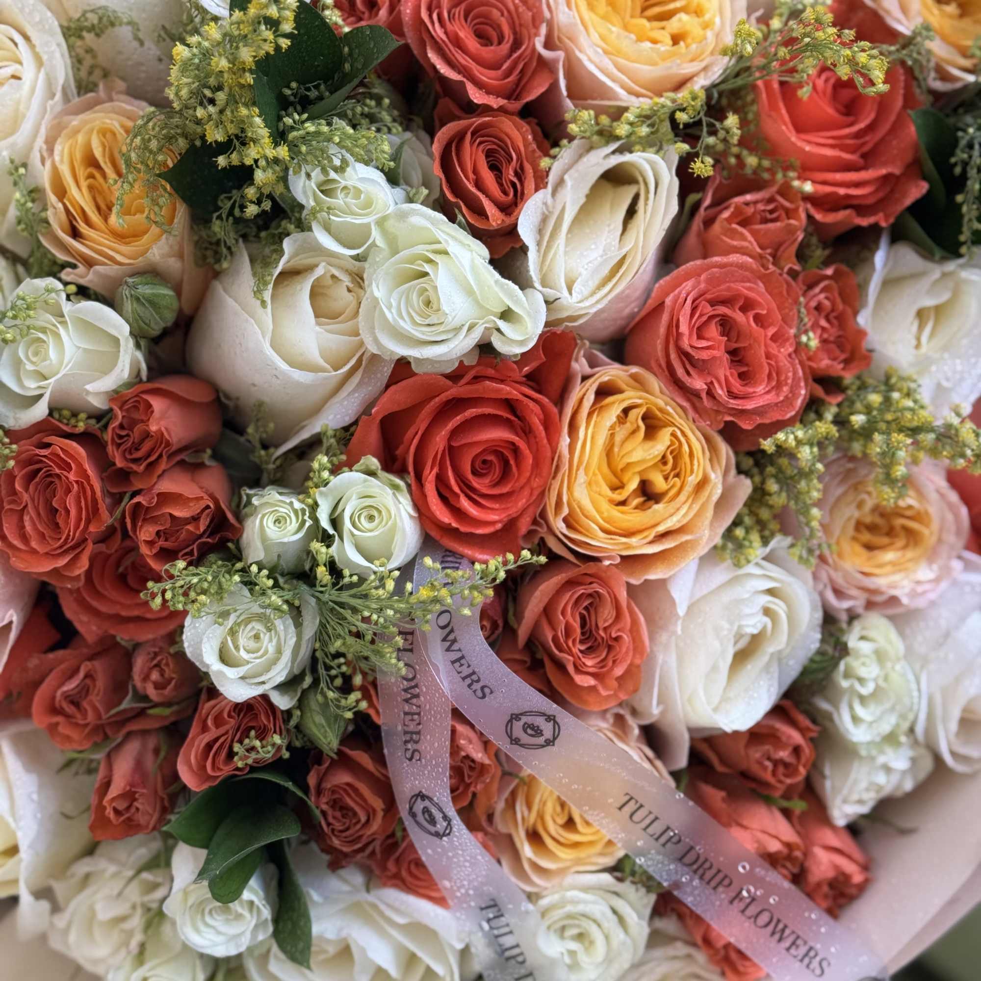 An abundant bouquet of cream, peach, and burnt orange garden roses wrapped