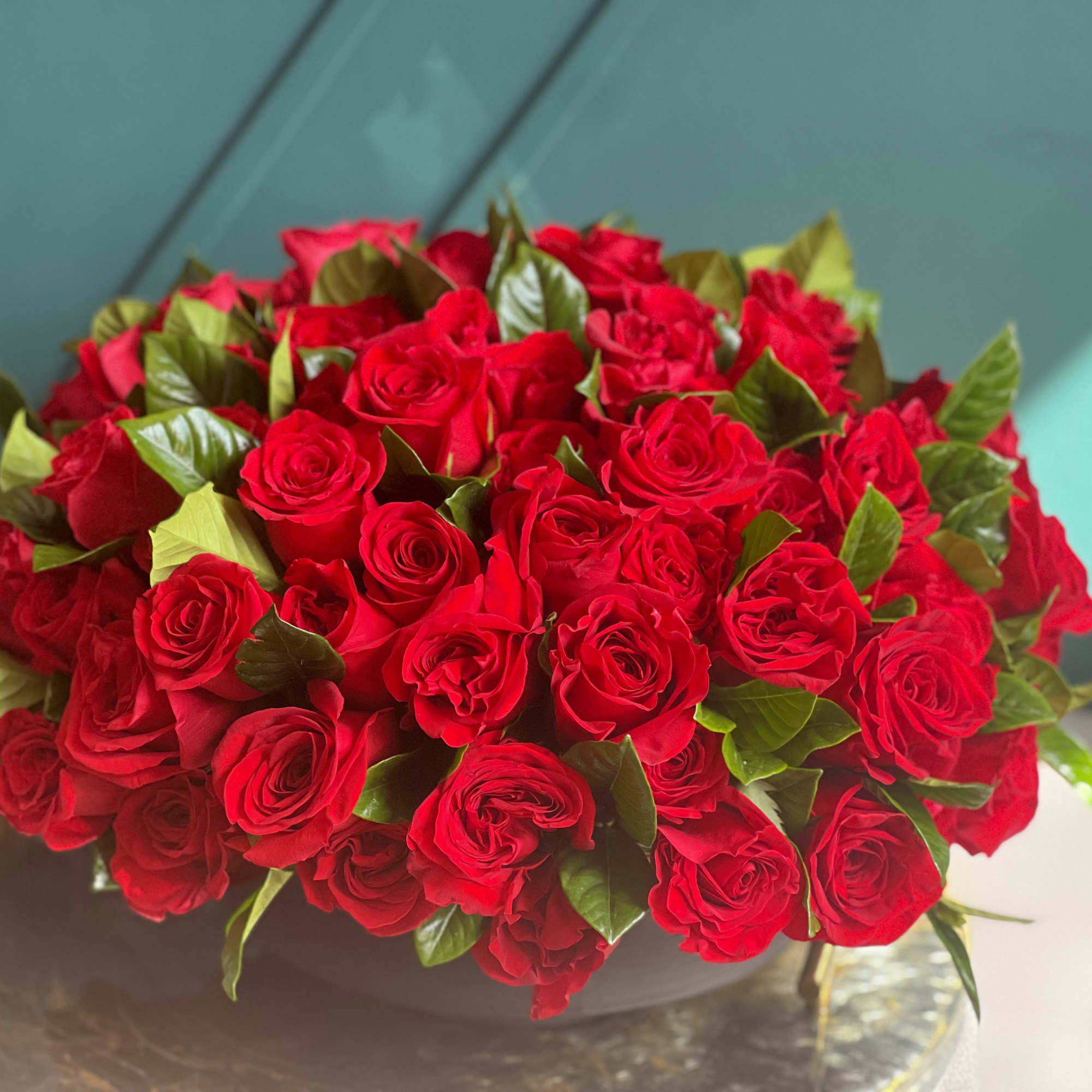 100 red roses in modern black vase 