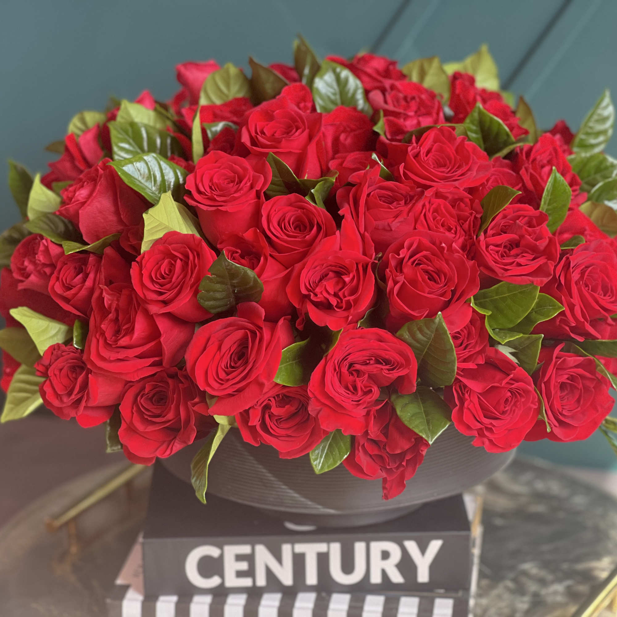 100 red roses in modern black vase 