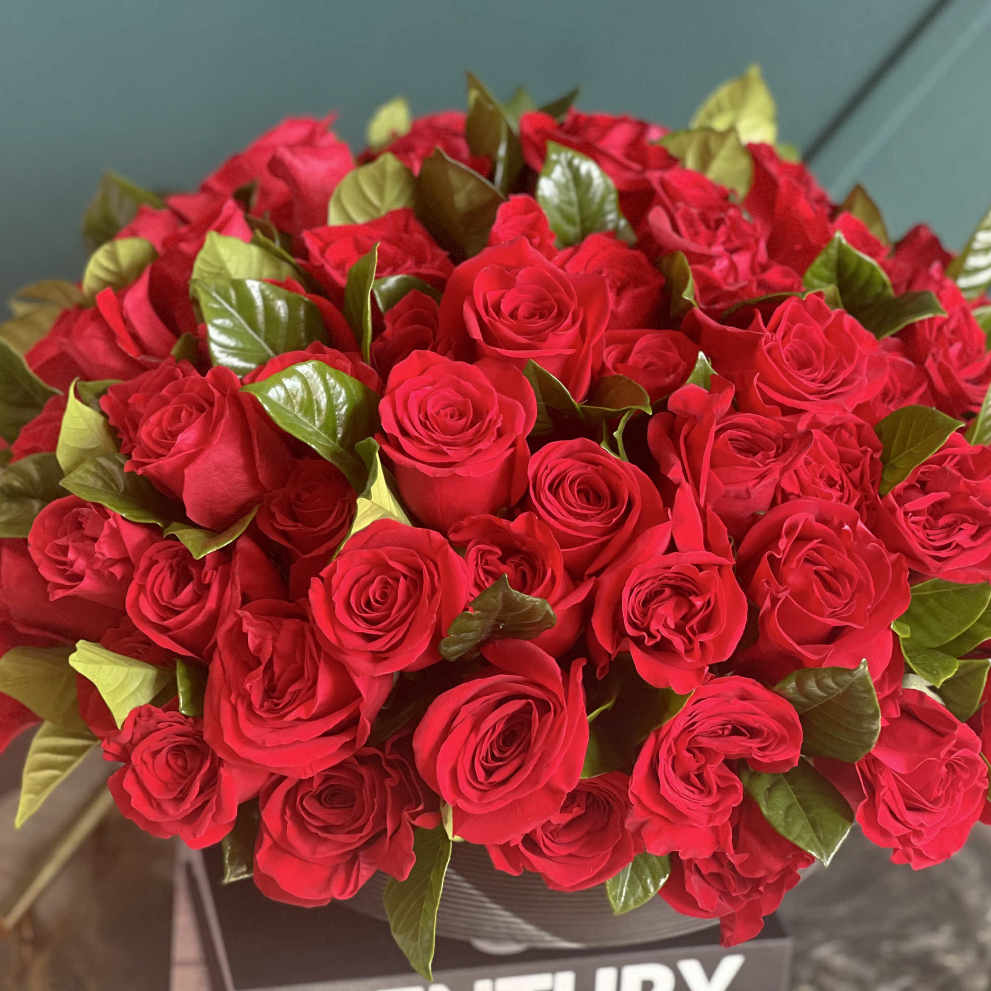 100 red roses in modern black vase 