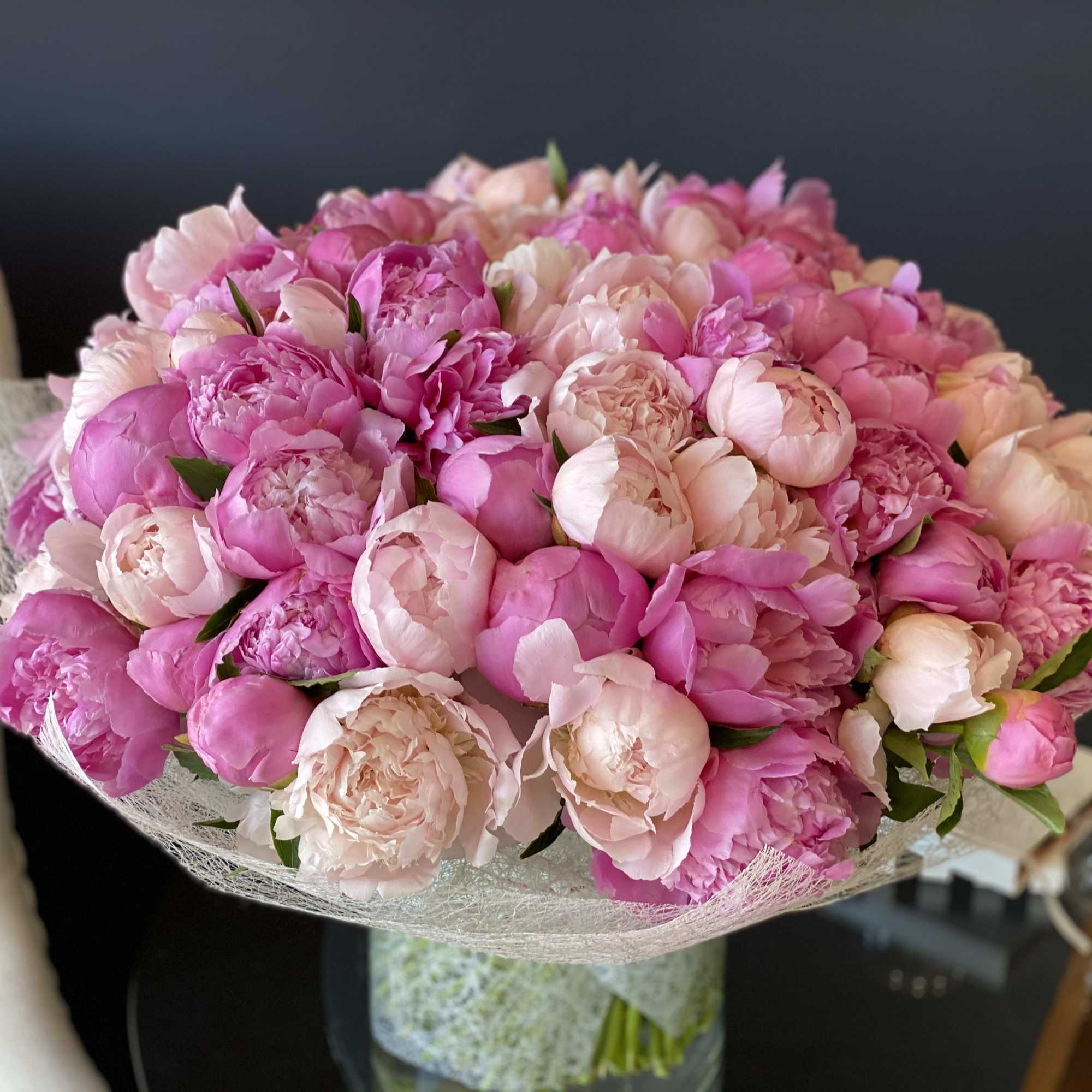 Hand-crafted Bouquet with 100 stems of luxurious peonies in clear vase.