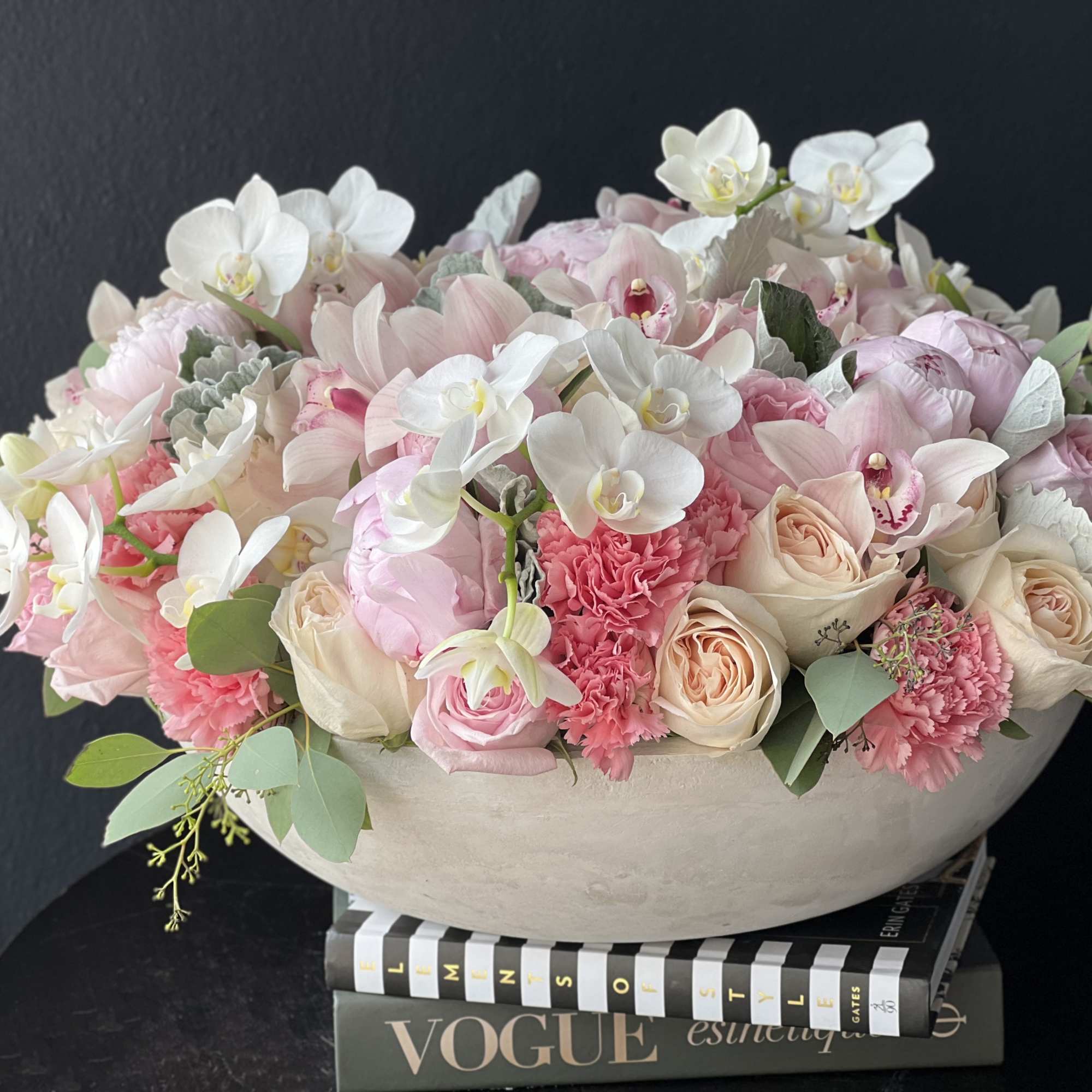 Large cement vase with mixed flowers. Large, lavish arrangement with roses, garden