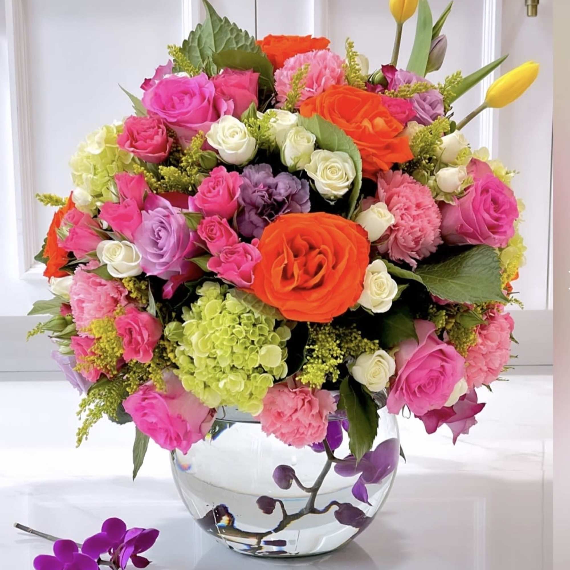 Glass bowl with submerged orchids and a full twist of summer bright