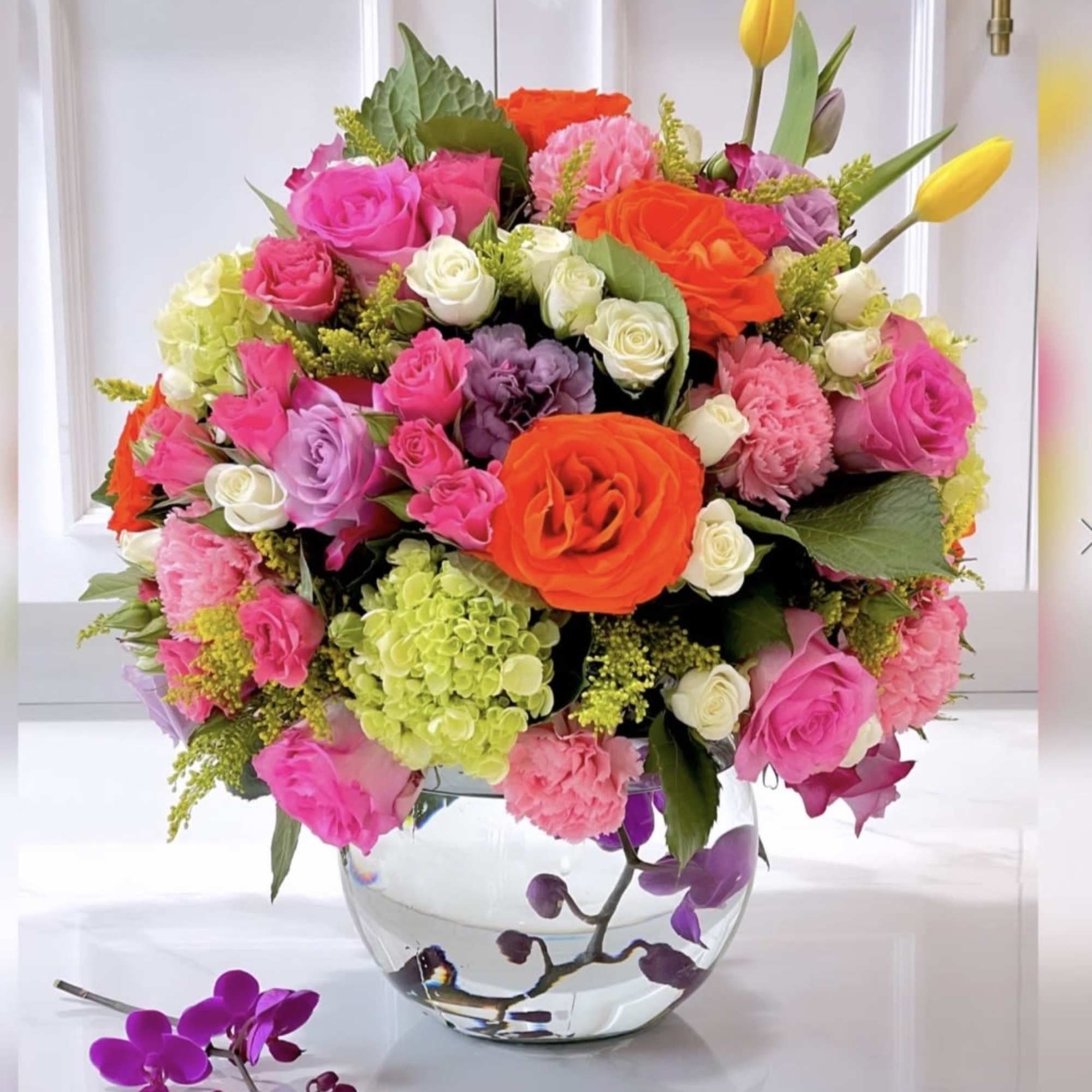 Glass bowl with submerged orchids and a full twist of summer bright