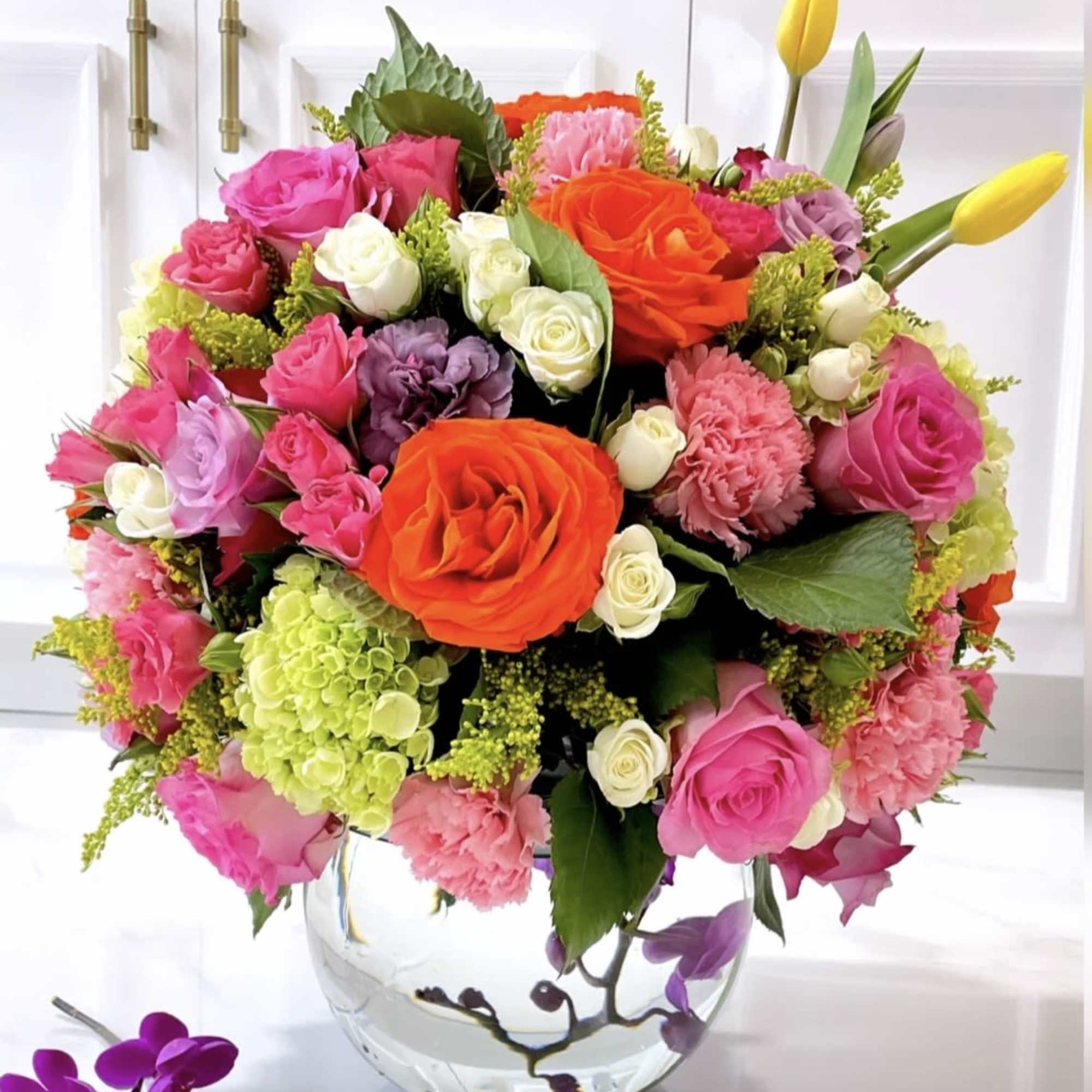 Glass bowl with submerged orchids and a full twist of summer bright