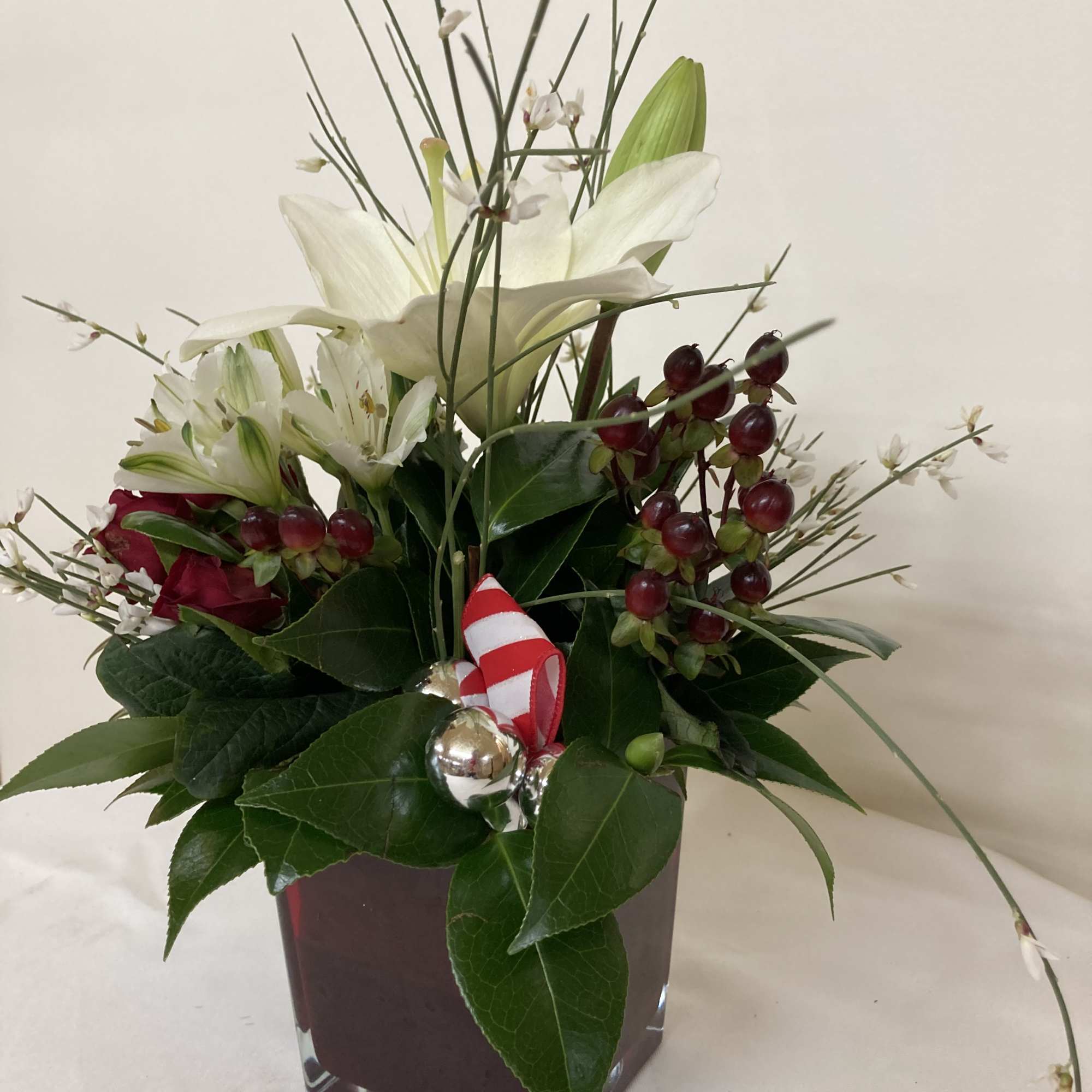 White lilies decorated for Christmas with silver ornaments and a red and