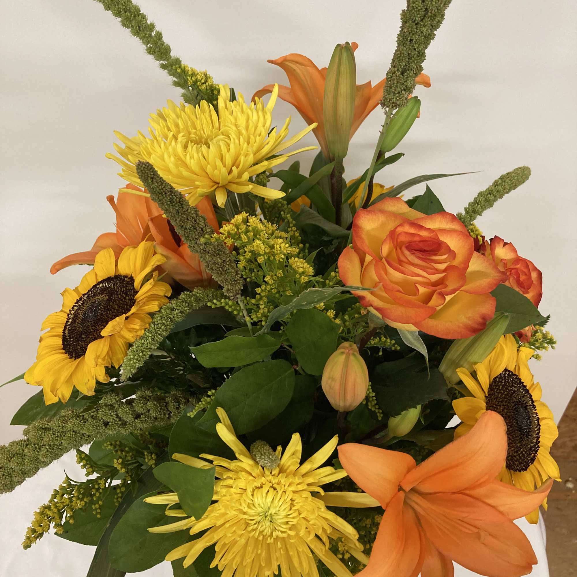 Orange  lilies and roses with yellow sunfowers and spider mums surrounded