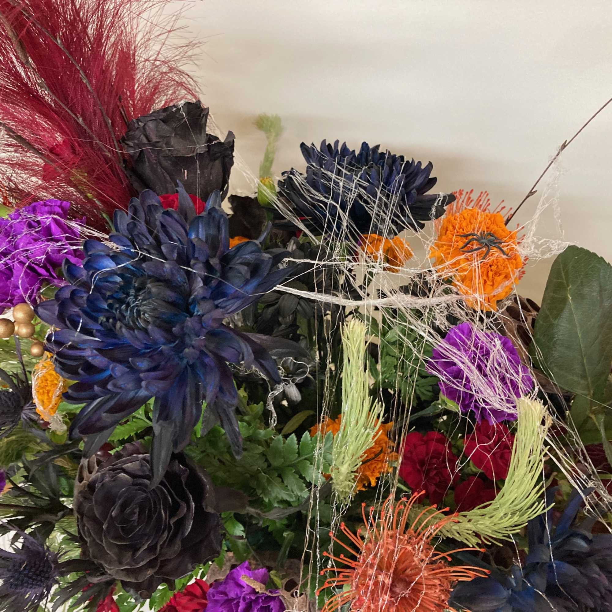 Give a creepy. crawly, spooky arrangements mad with mums, carnations, roses, marigolds
