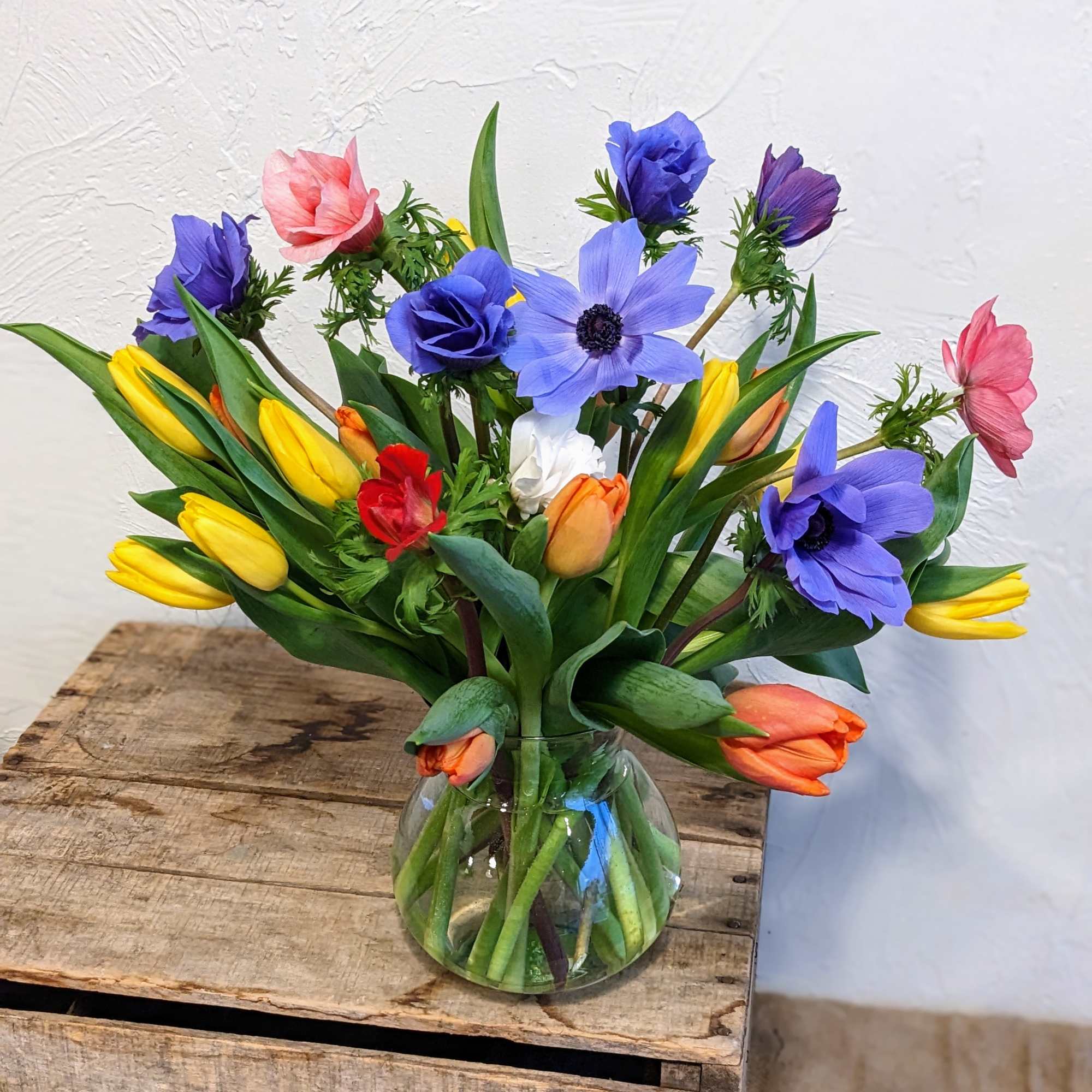 Ring in spring with this beautiful arrangement of anemones and tulips. Arranged