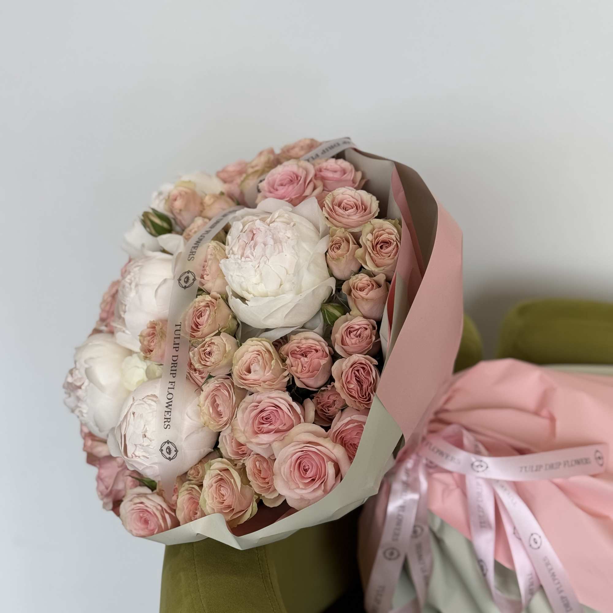 A breathtaking bouquet of lush peonies and blush roses, wrapped beautifully and