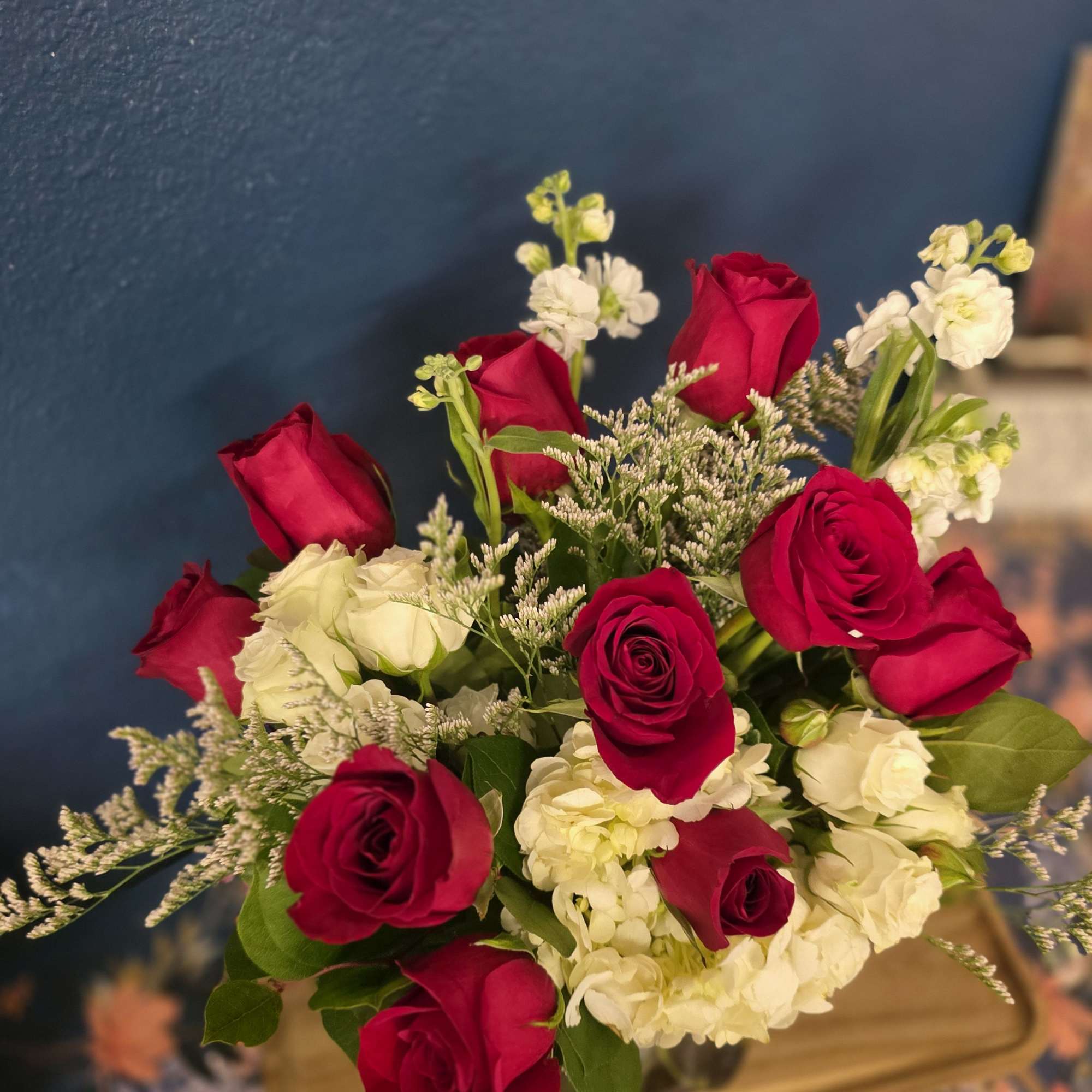 Red roses, hydrangea, spray roses and greenery designed in a gorgeous crystal