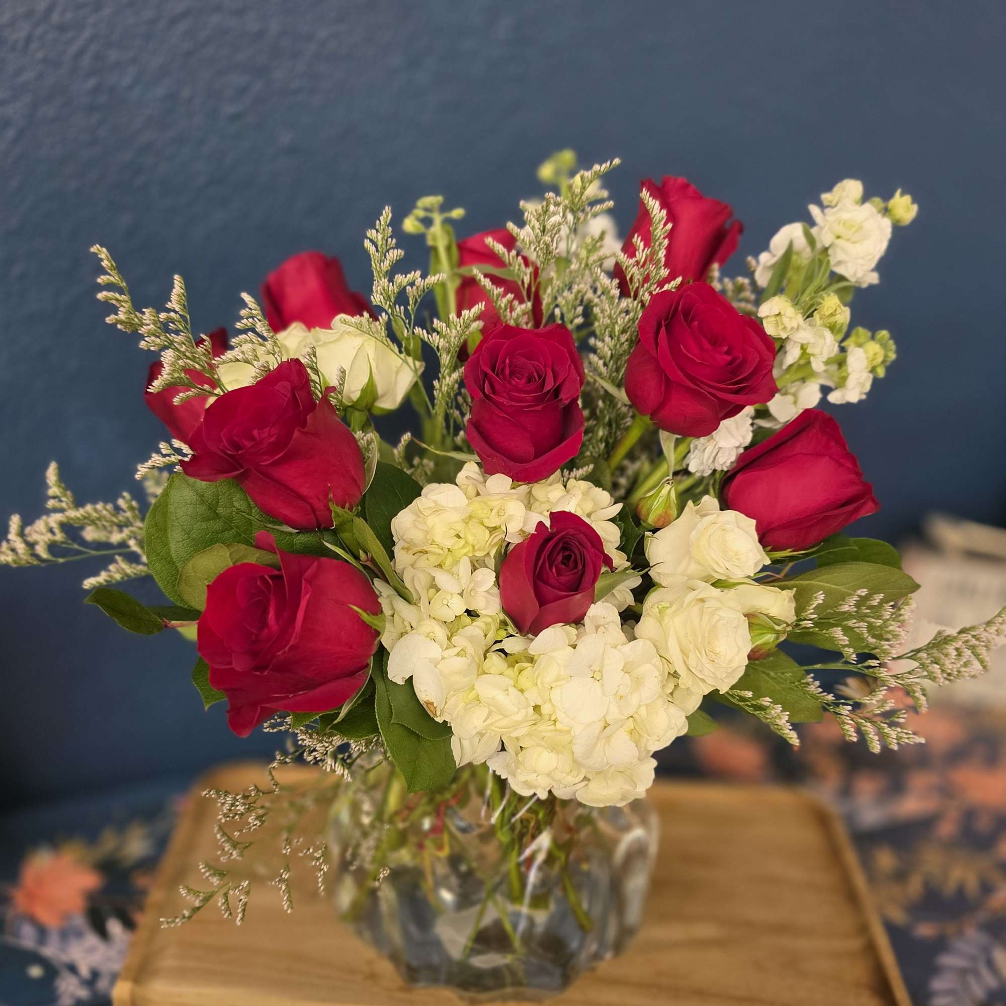 Red roses, hydrangea, spray roses and greenery designed in a gorgeous crystal