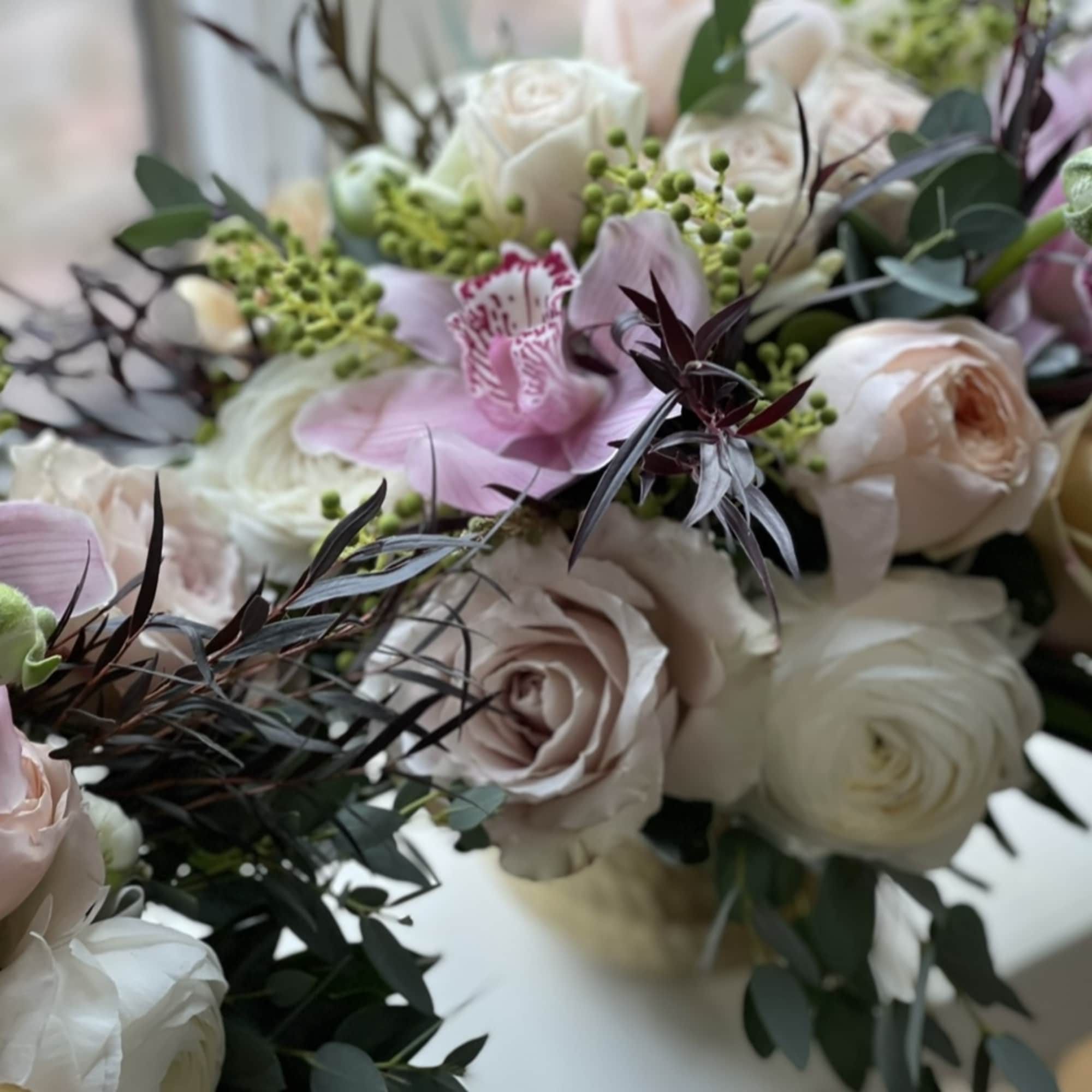 Elegant, classy, subtle, soft. Pale pink and white blooms accented with dark