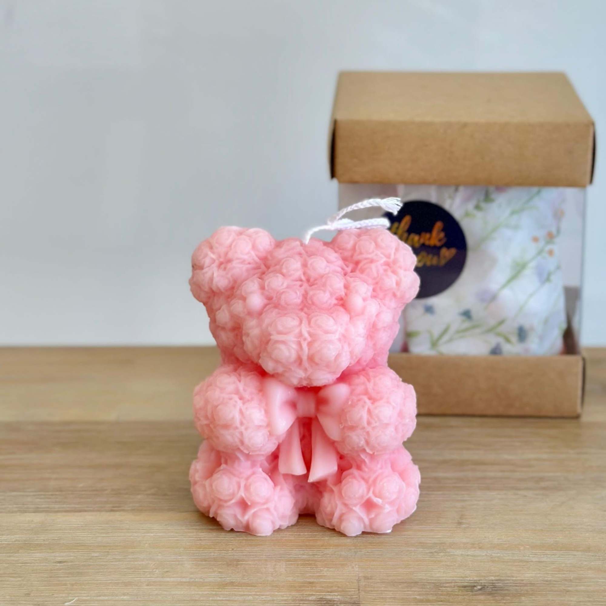 A handmade teddy bear candle crafted from delicate rose-shaped wax details. Perfect