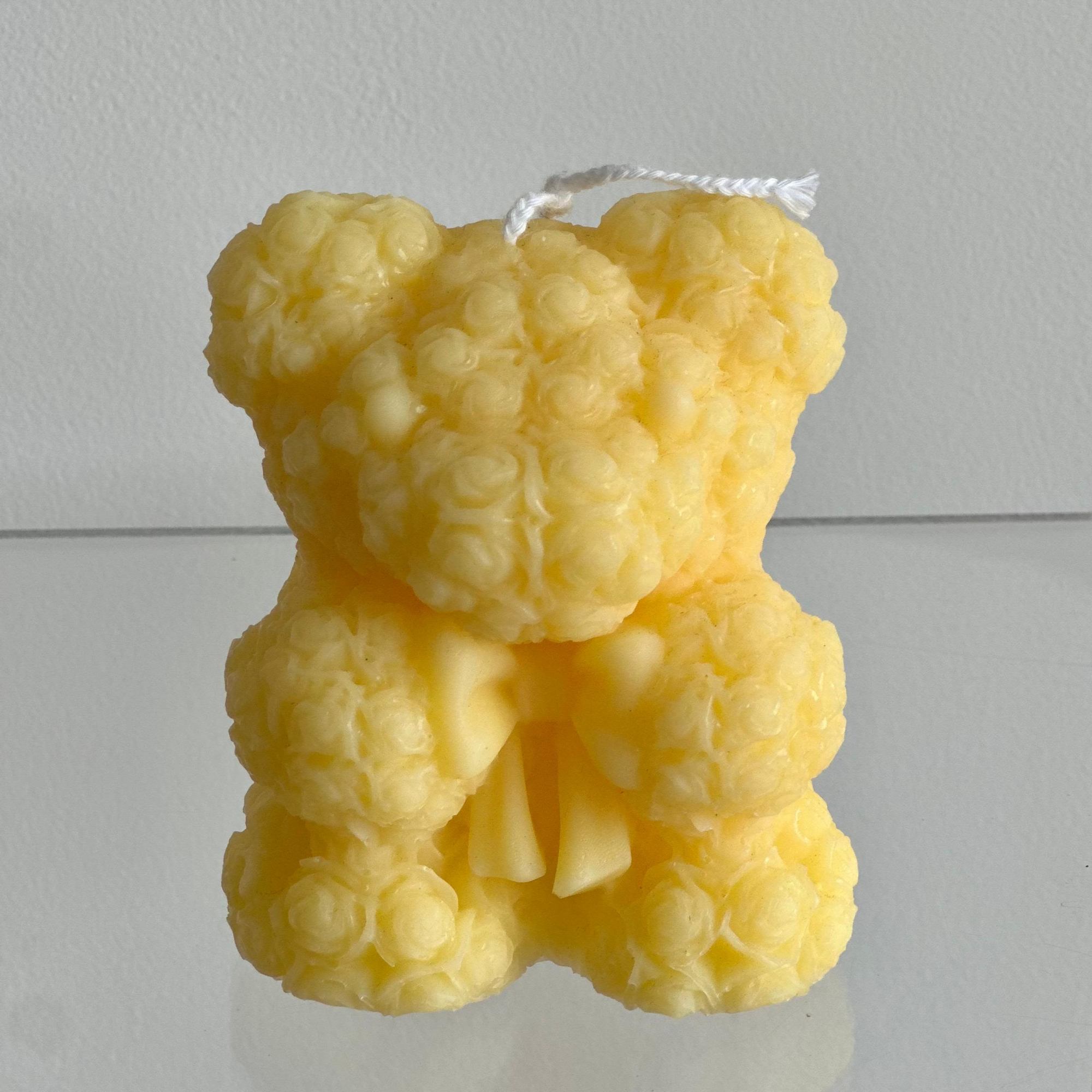 A handmade teddy bear candle crafted from delicate rose-shaped wax details. Perfect