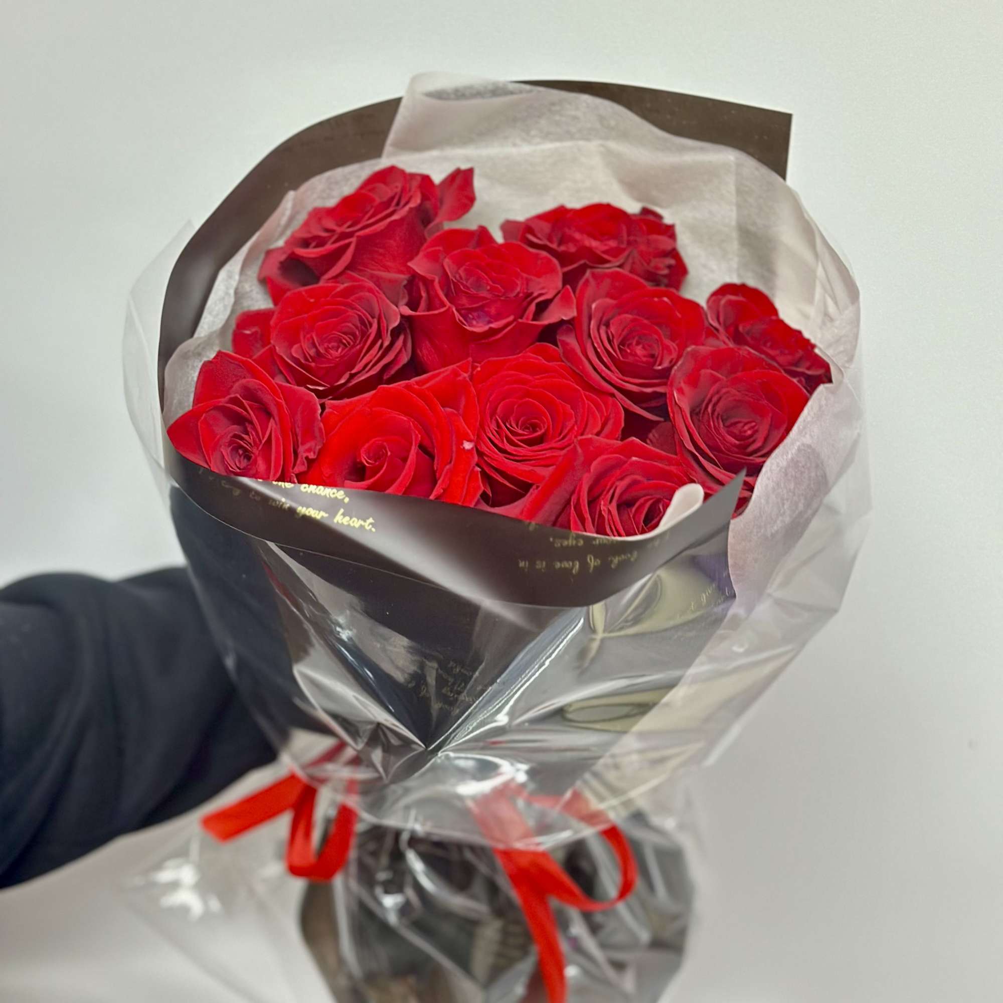 A round bouquet of a dozen roses wrapped in black paper. 

Flower