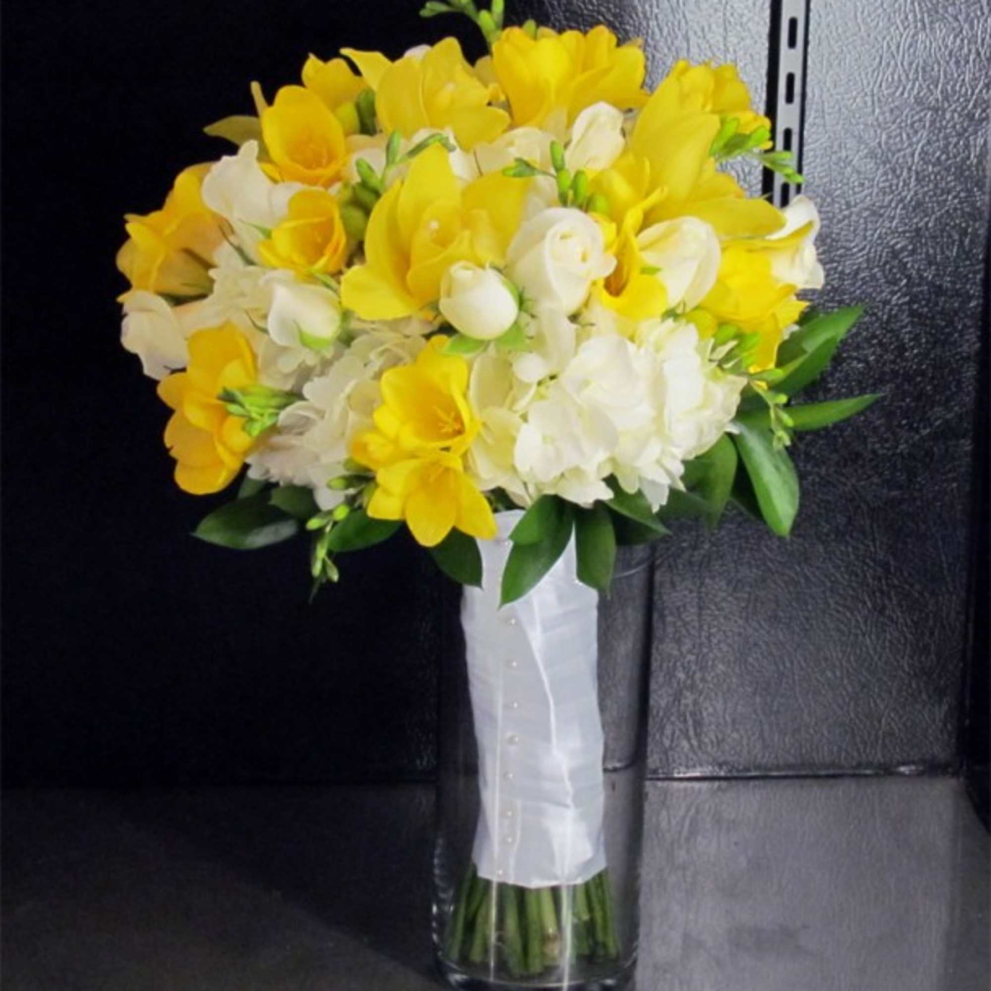 This premium bridal bouquet features White Hydrangeas, White Spray Roses, Yellow Cymbidium