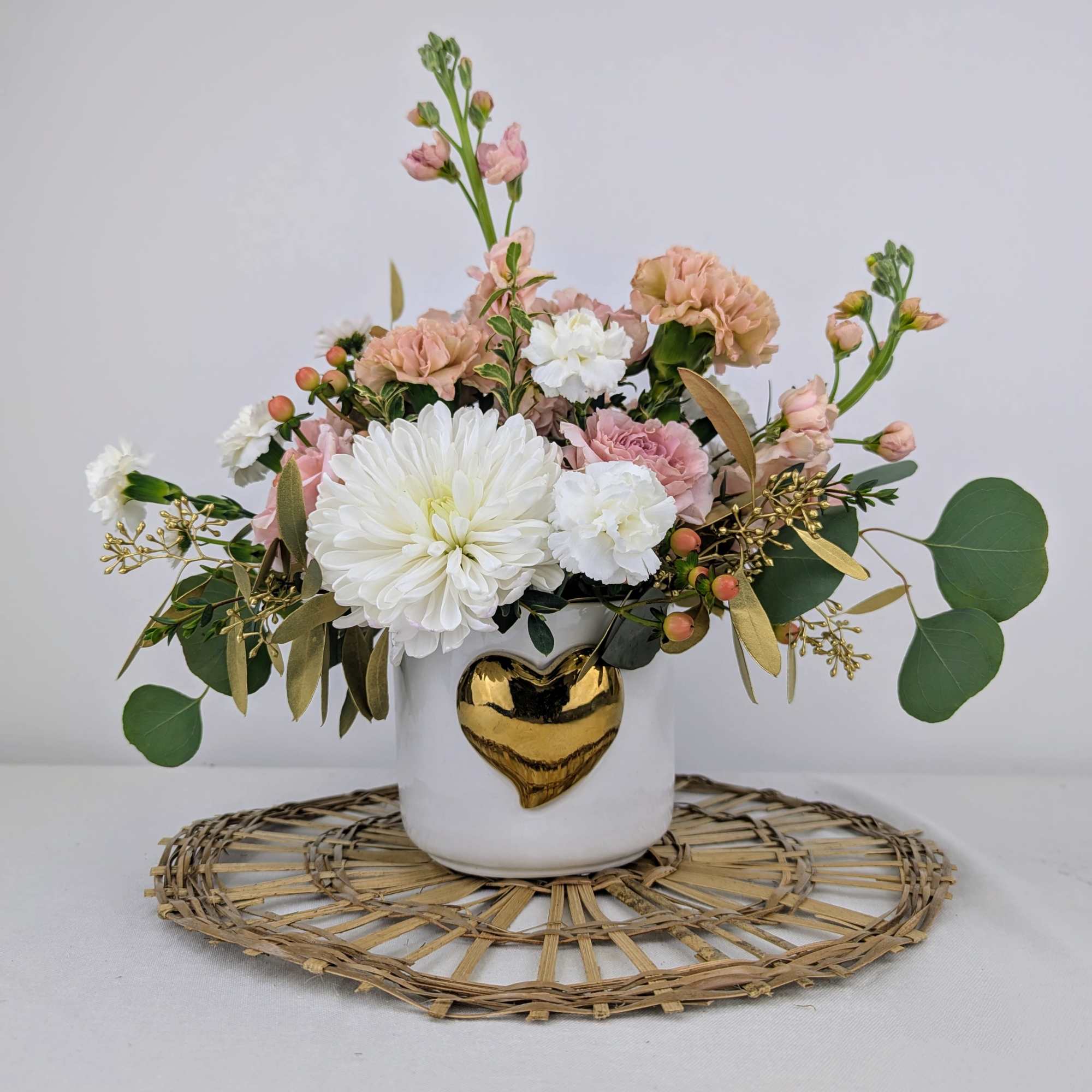 A soft pink and white arrangement with a touch of gold designed