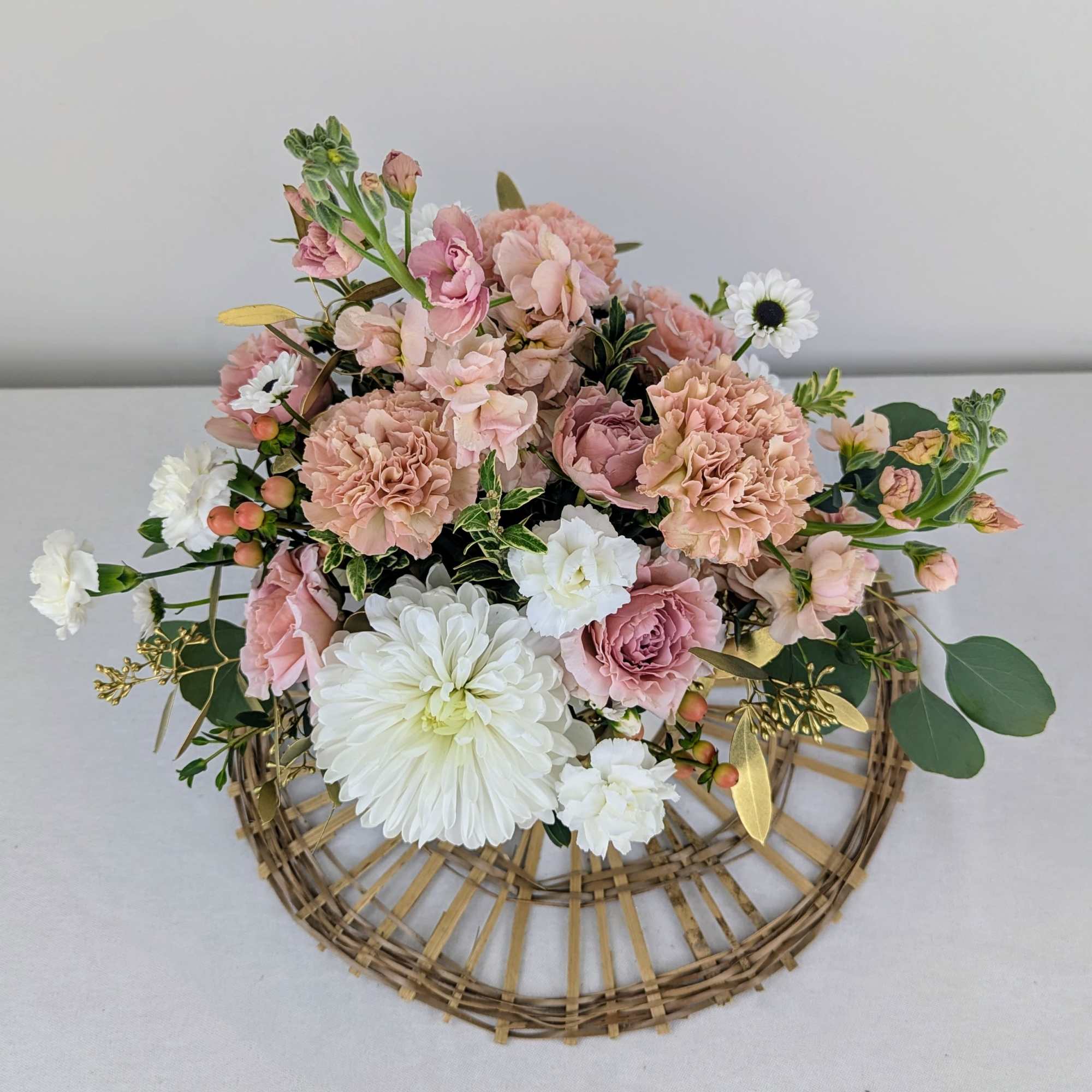 A soft pink and white arrangement with a touch of gold designed