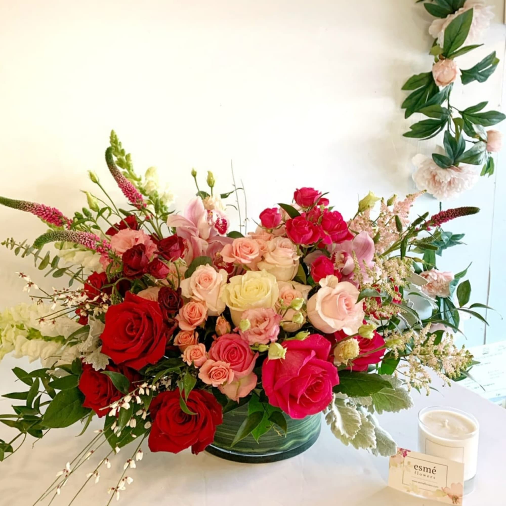 A beautiful arrangement of cymbidium orchids with red roses, Secret Garden roses