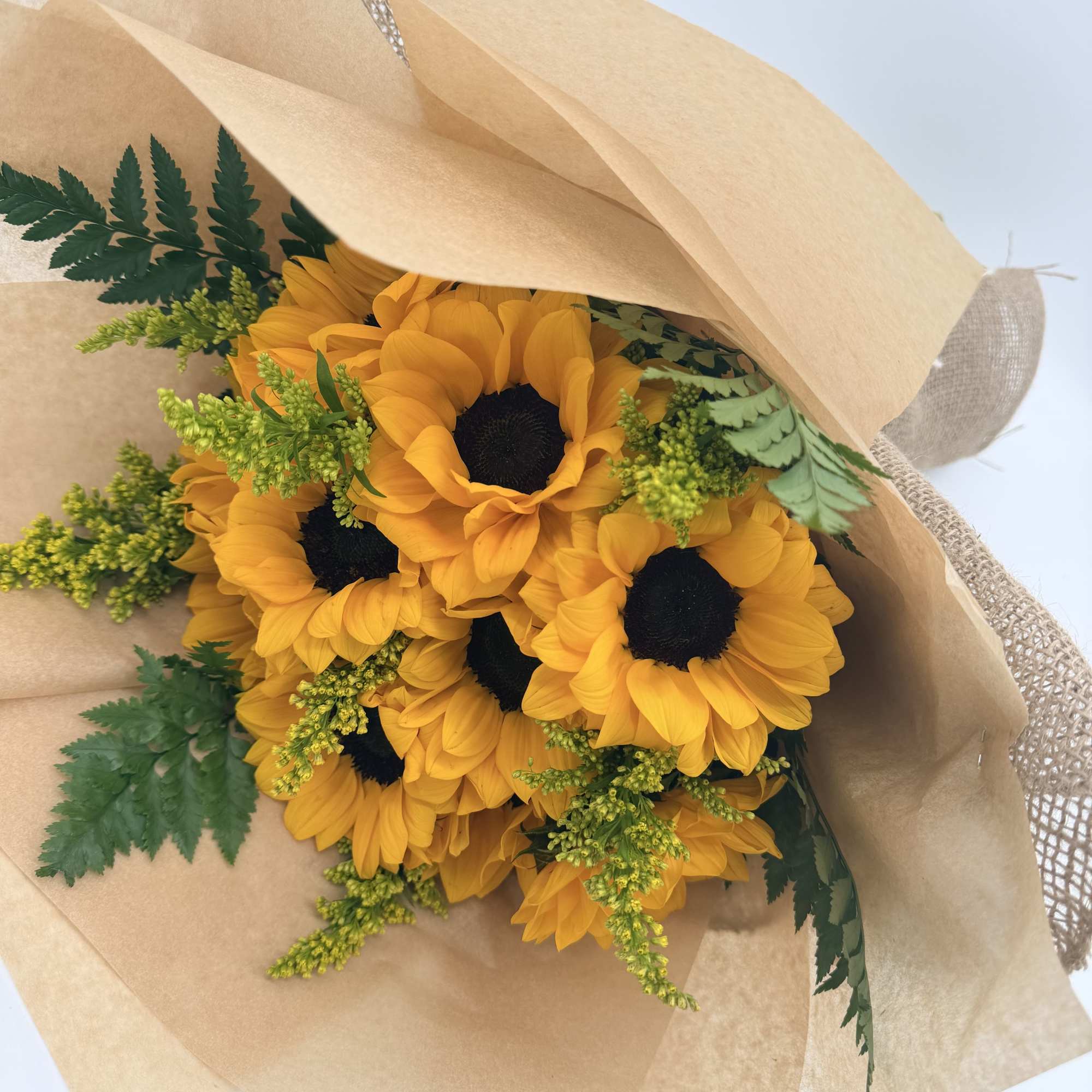 A sweet cluster of golden sunflowers wrapped simply and beautifully with natural