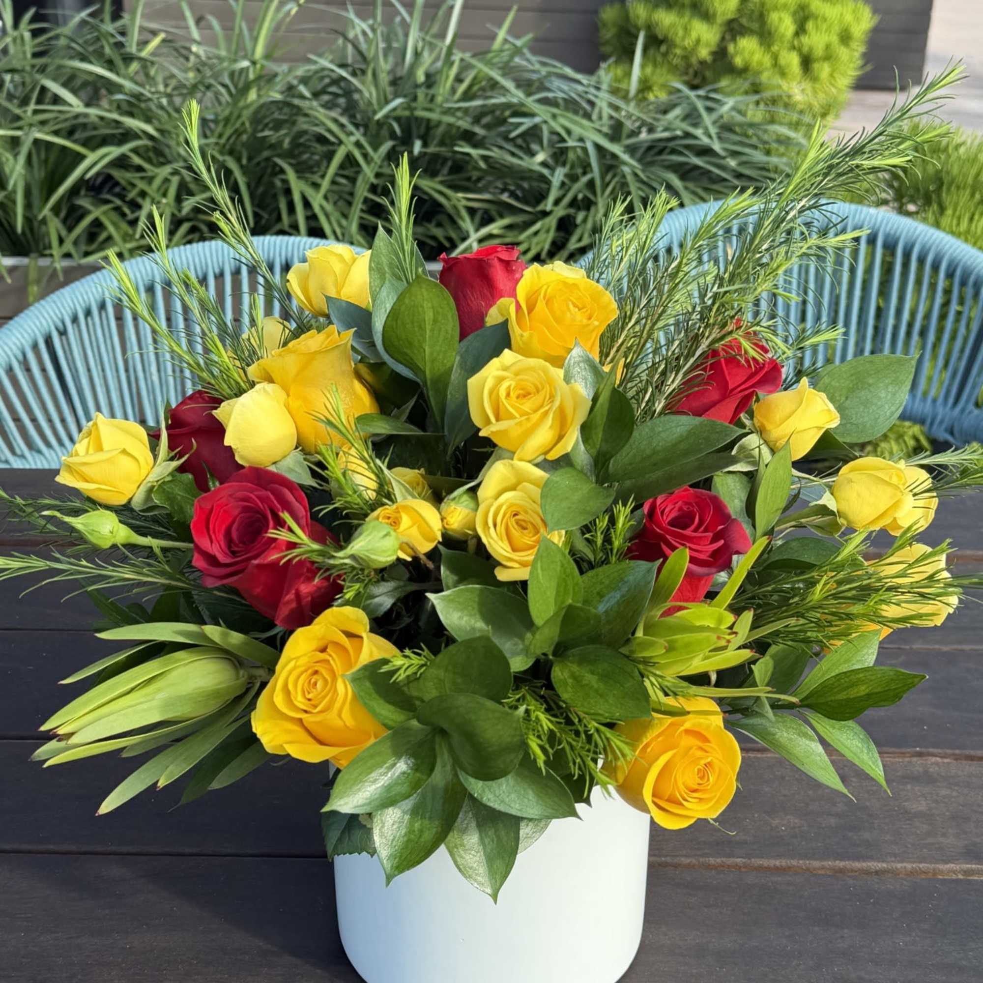 A romantic blend of red and golden roses, beautifully accented with lush