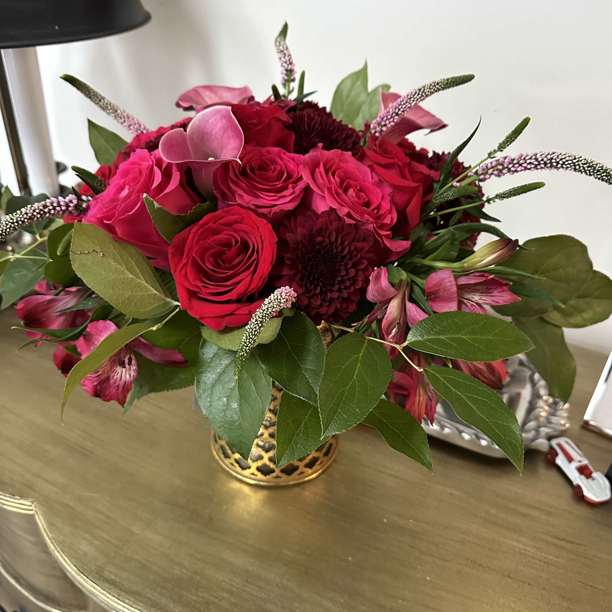 A lush bouquet of jewel-toned blooms arranged in a vase. 