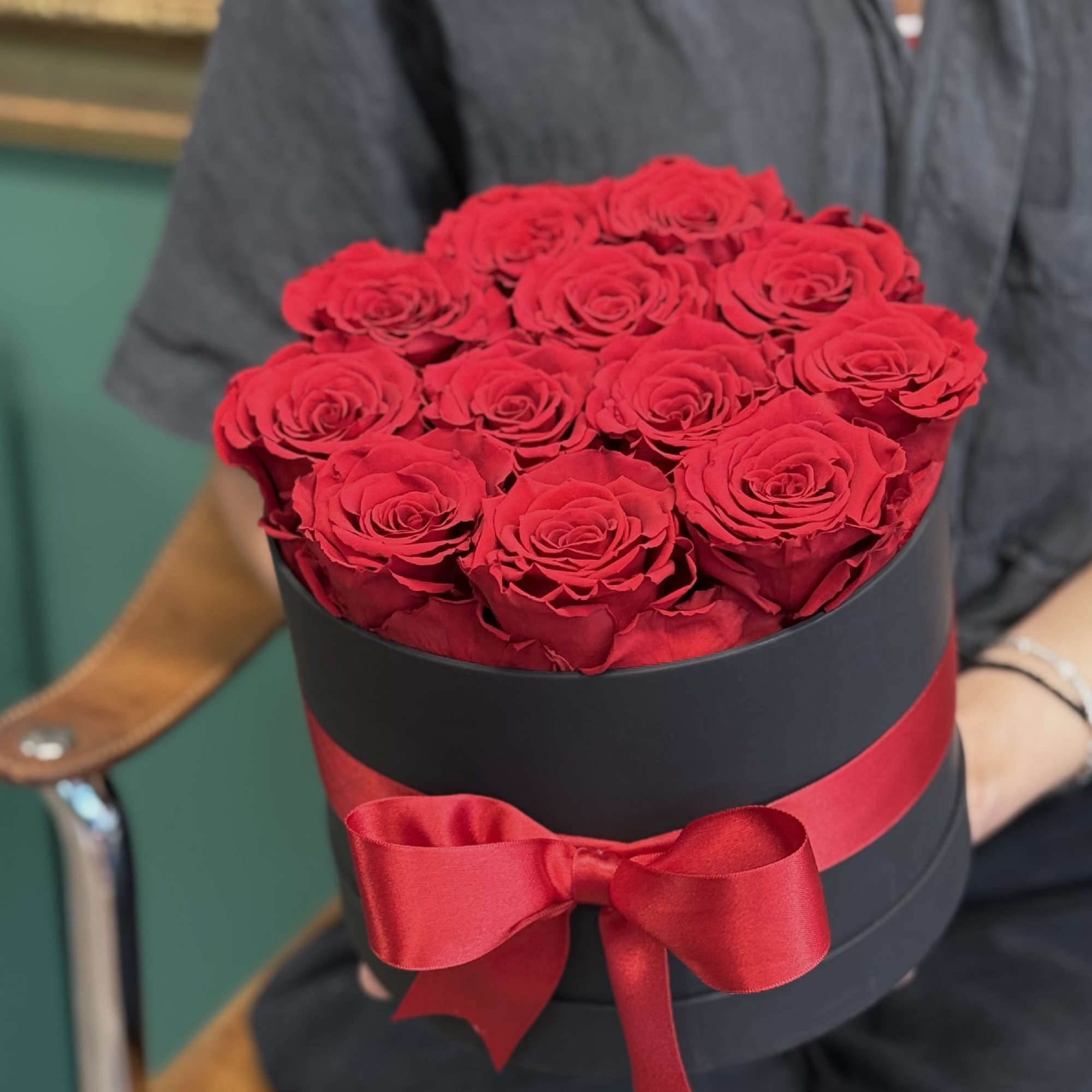 Twelve preserved red roses, carefully arranged in a sleek black box and