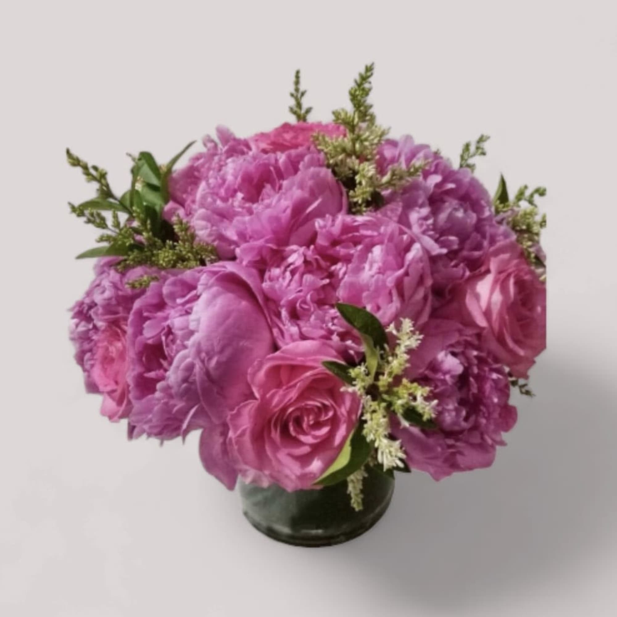 This arrangement is made up of pink roses and pink peonies. Vase