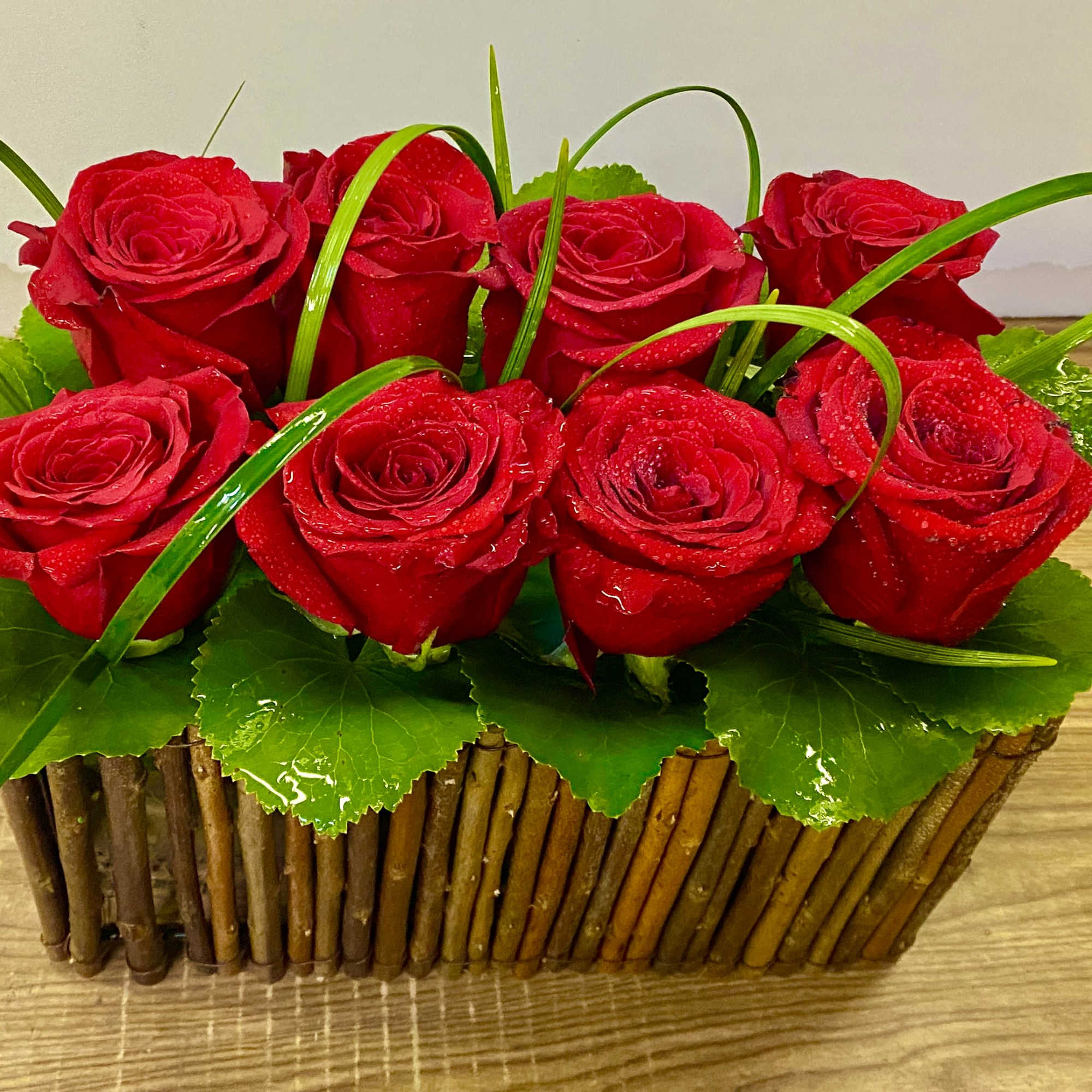 10 red roses in a wood basket 