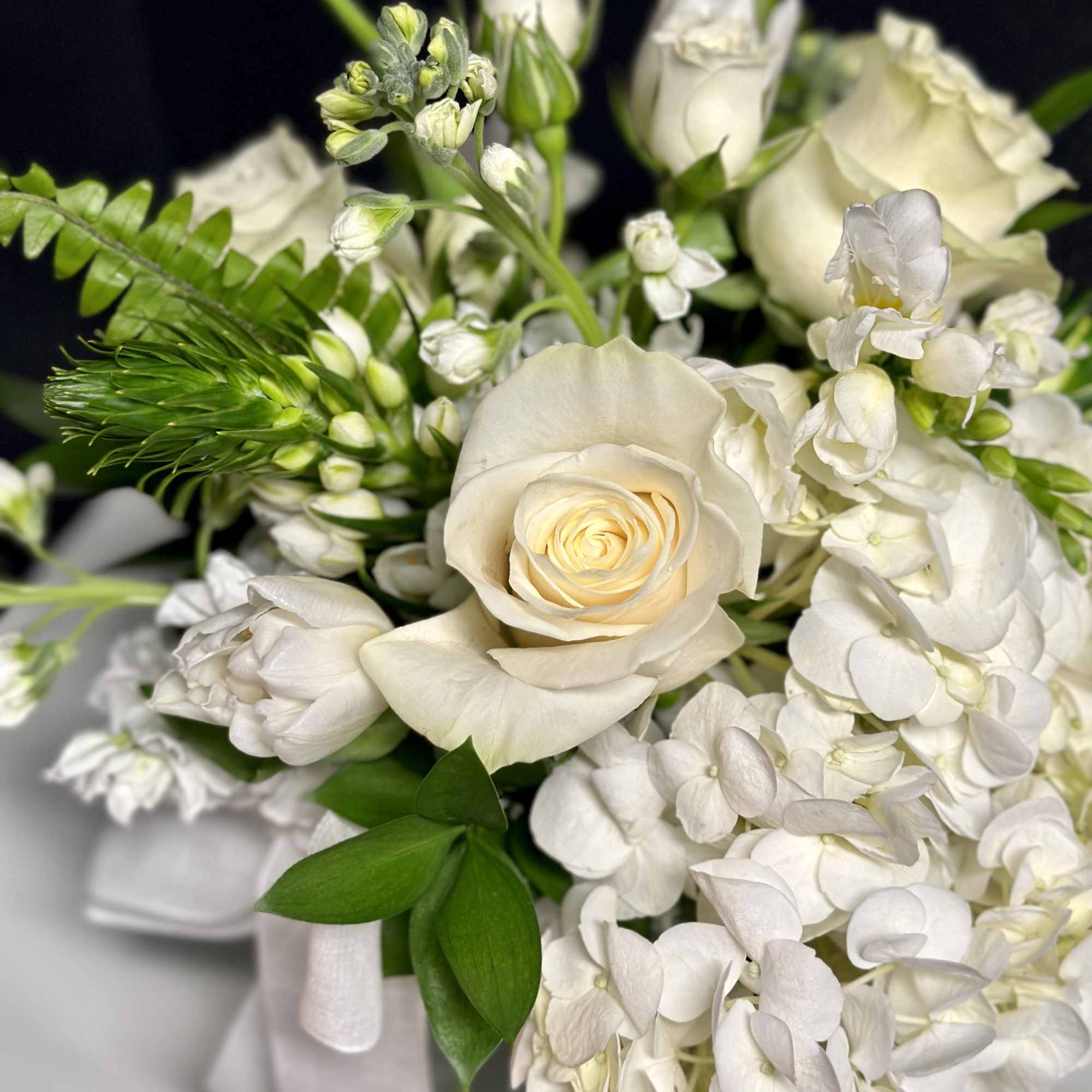 An elegant seasonal garden mix in creamy whites and greens. Arranged low
