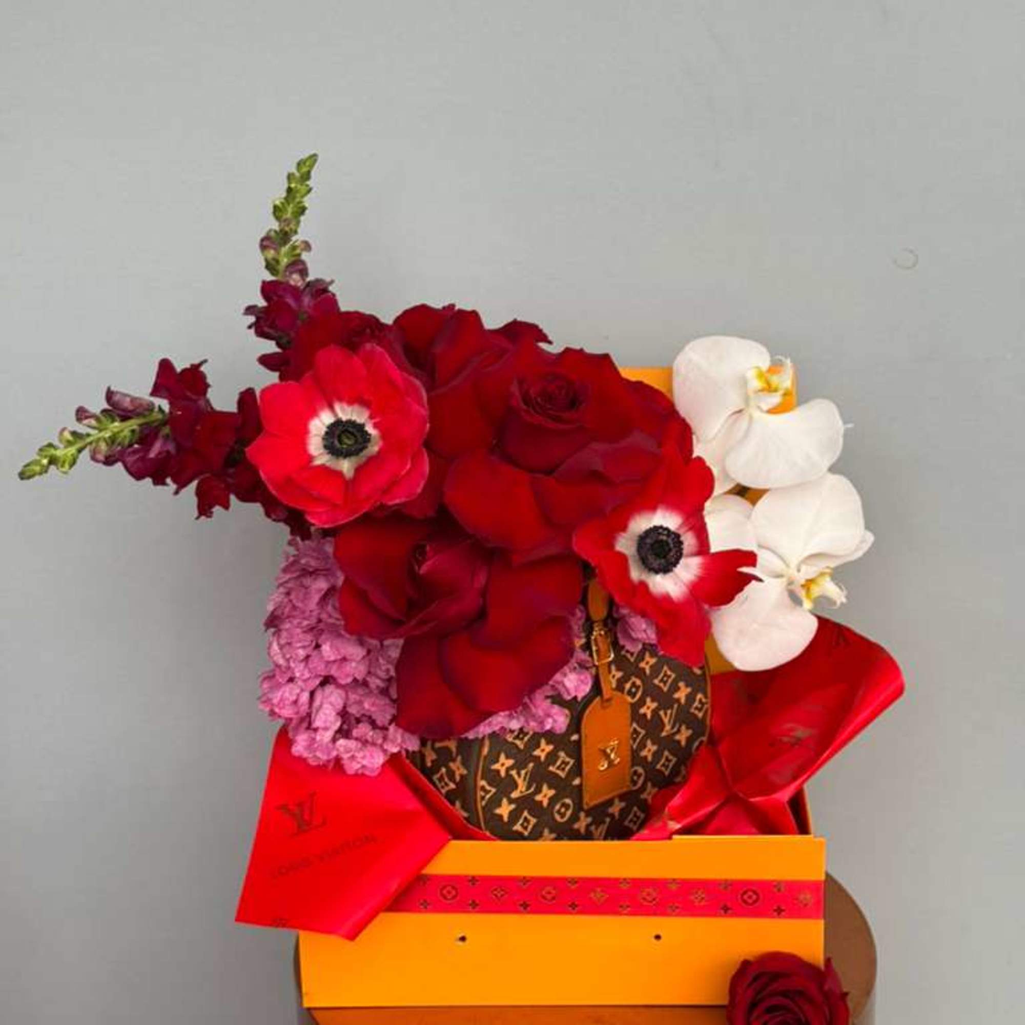Elegant red roses paired with graceful blooms beautifully arranged in a designer-inspired